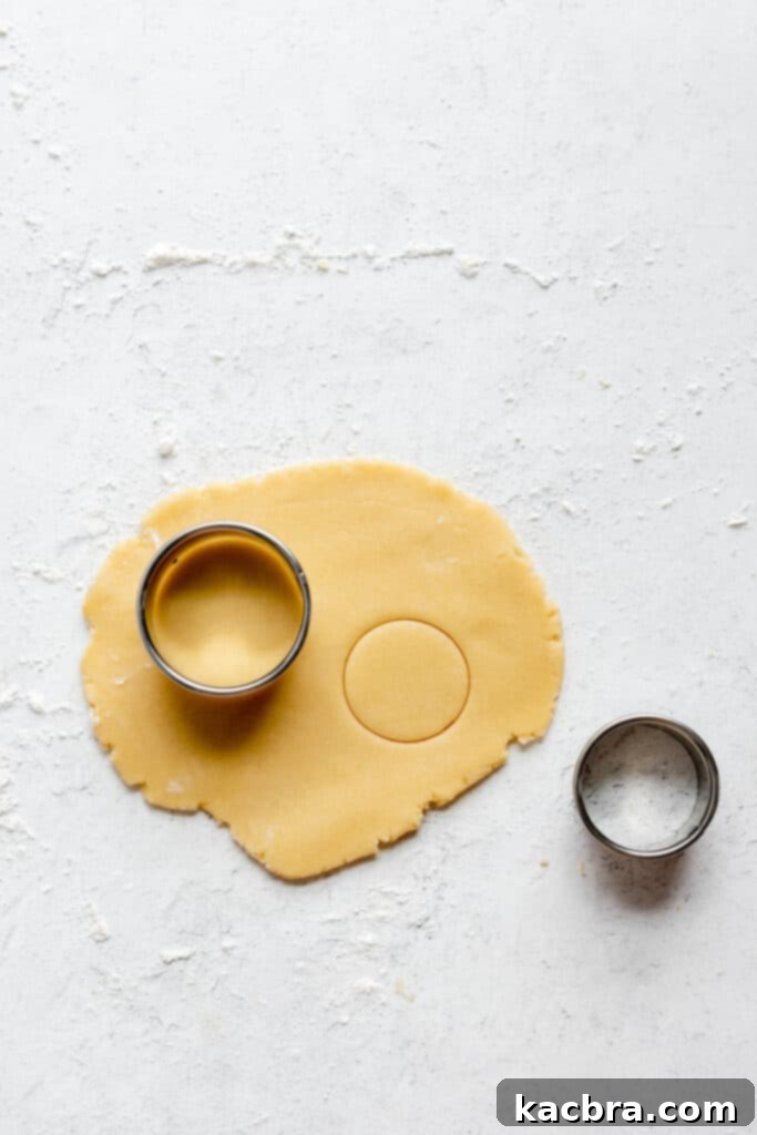 A tart shell carefully placed into a tart pan with a removable bottom, showing how it fits the contours.