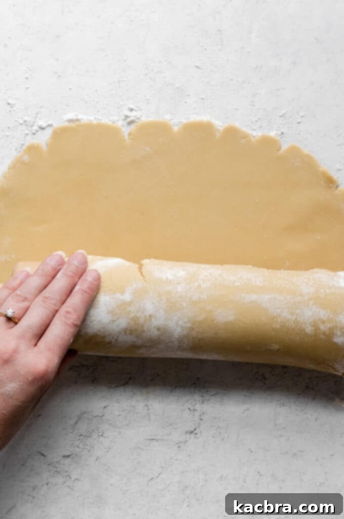 Rolling the pâté sucrée dough to the correct thickness and size for a tart pan.