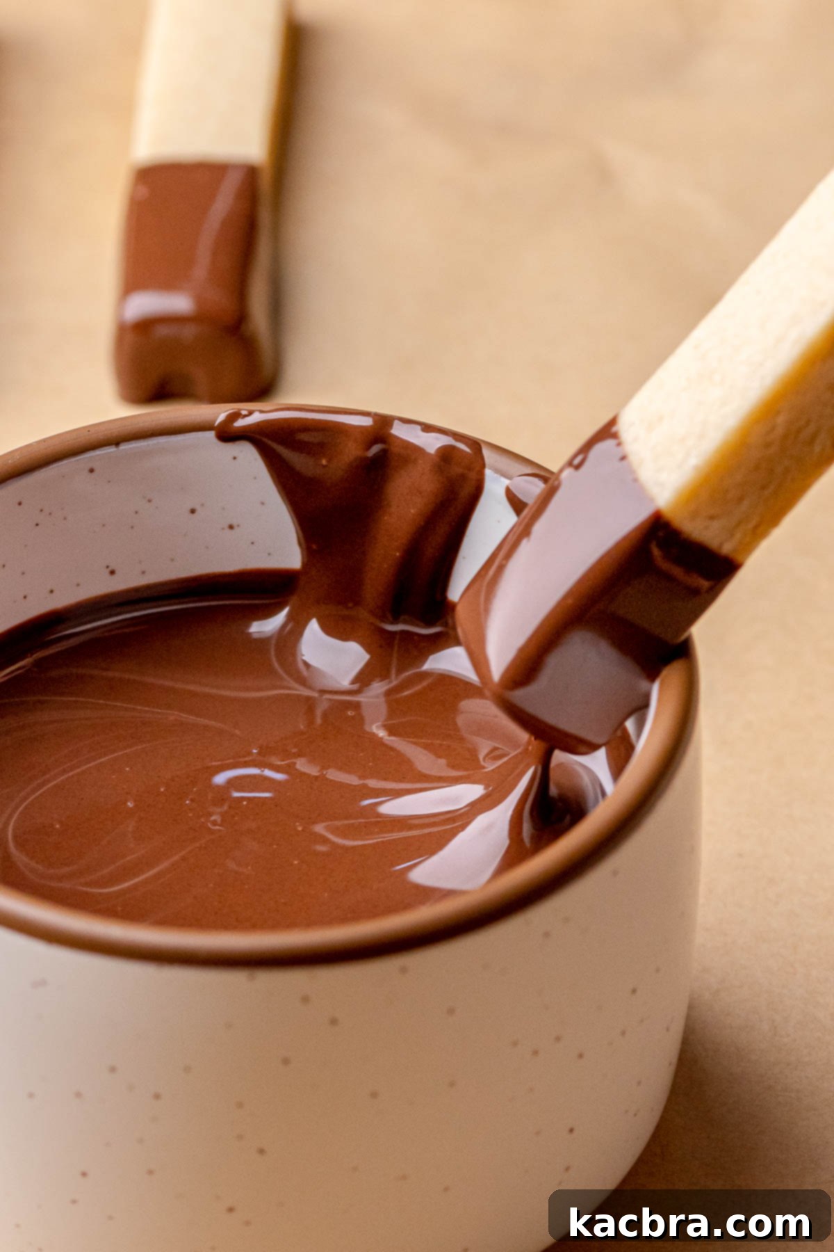 Irresistible Chocolate Cookie Dippers 16 A chocolate-dipped cookie stick being carefully pulled out of a bowl of rich melted chocolate.