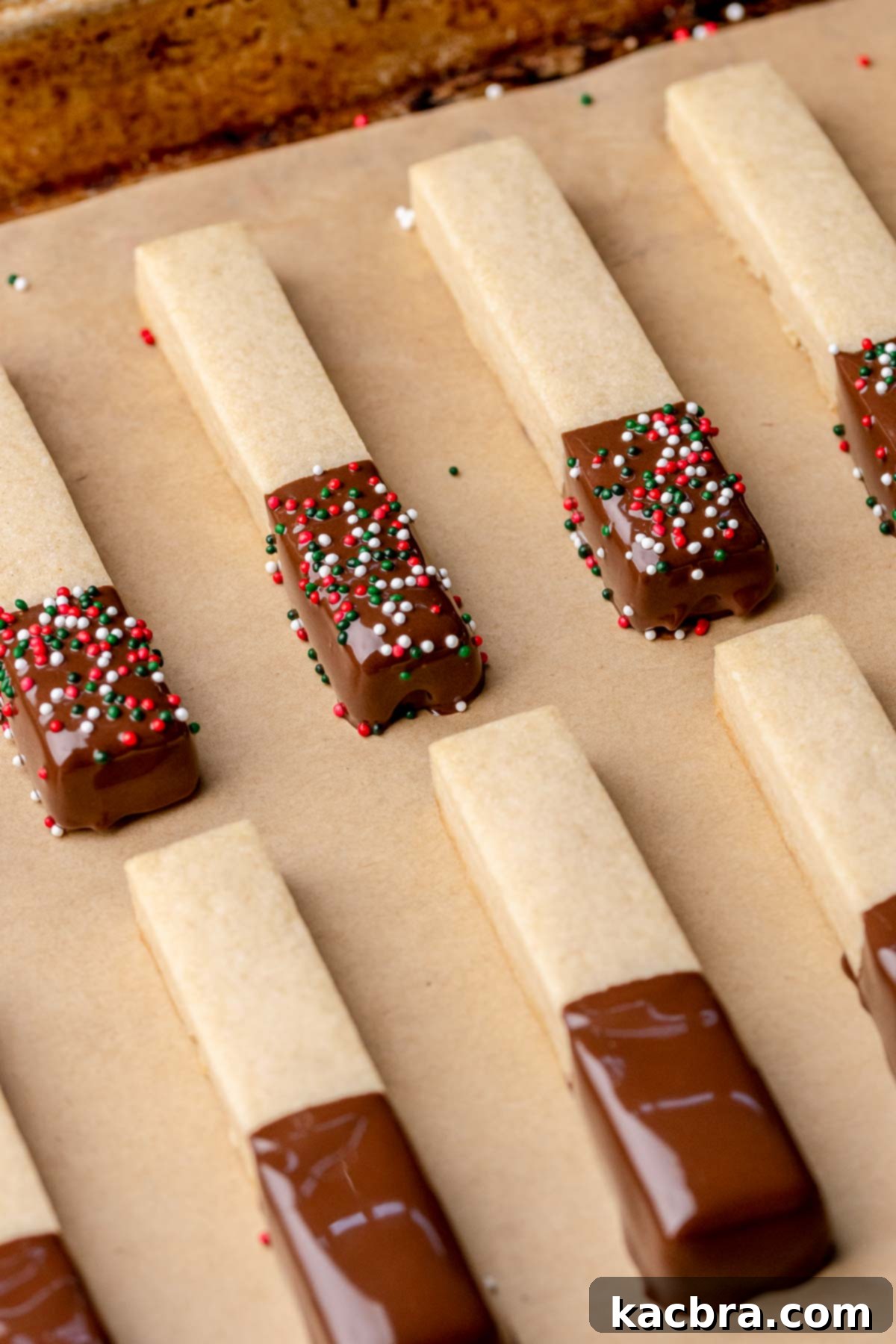 Irresistible Chocolate Cookie Dippers 17 Chocolate-dipped cookie sticks on a pan, adorned with colorful sprinkles while the chocolate is still wet.