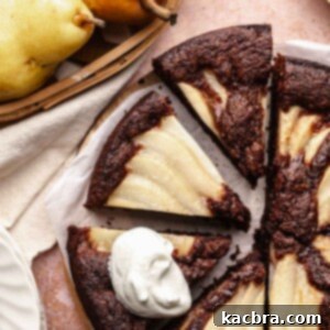 Pear-Kissed Chocolate Cake 14 Sliced chocolate pear cake. One slice has a dollop of whipped cream on it.