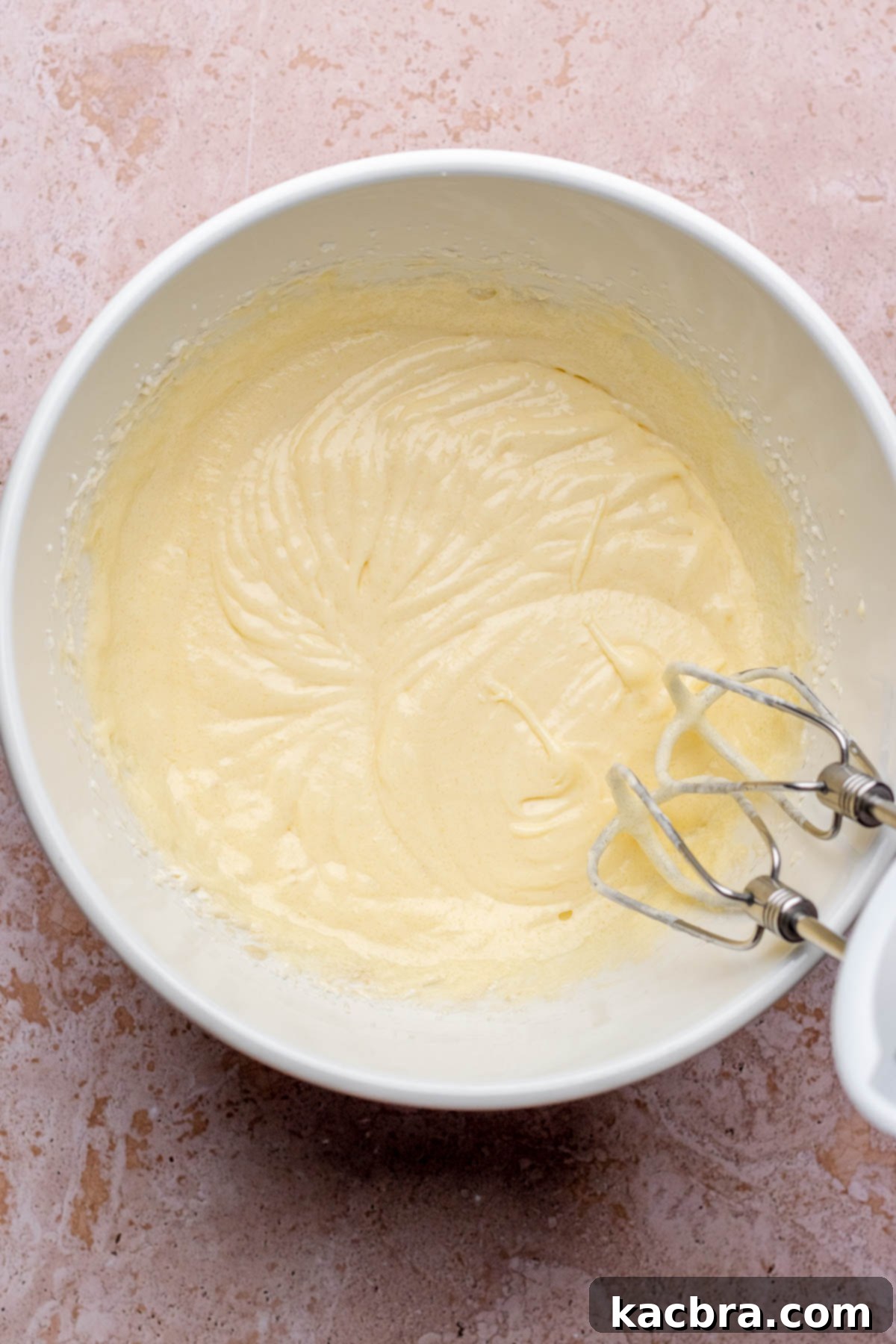 Pear-Kissed Chocolate Cake 4 A hand mixer mixes wet ingredients for cake batter in a bowl.