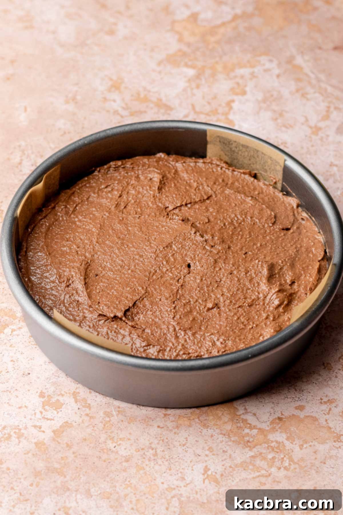 Pear-Kissed Chocolate Cake 7 Chocolate cake batter spread in a round cake pan.