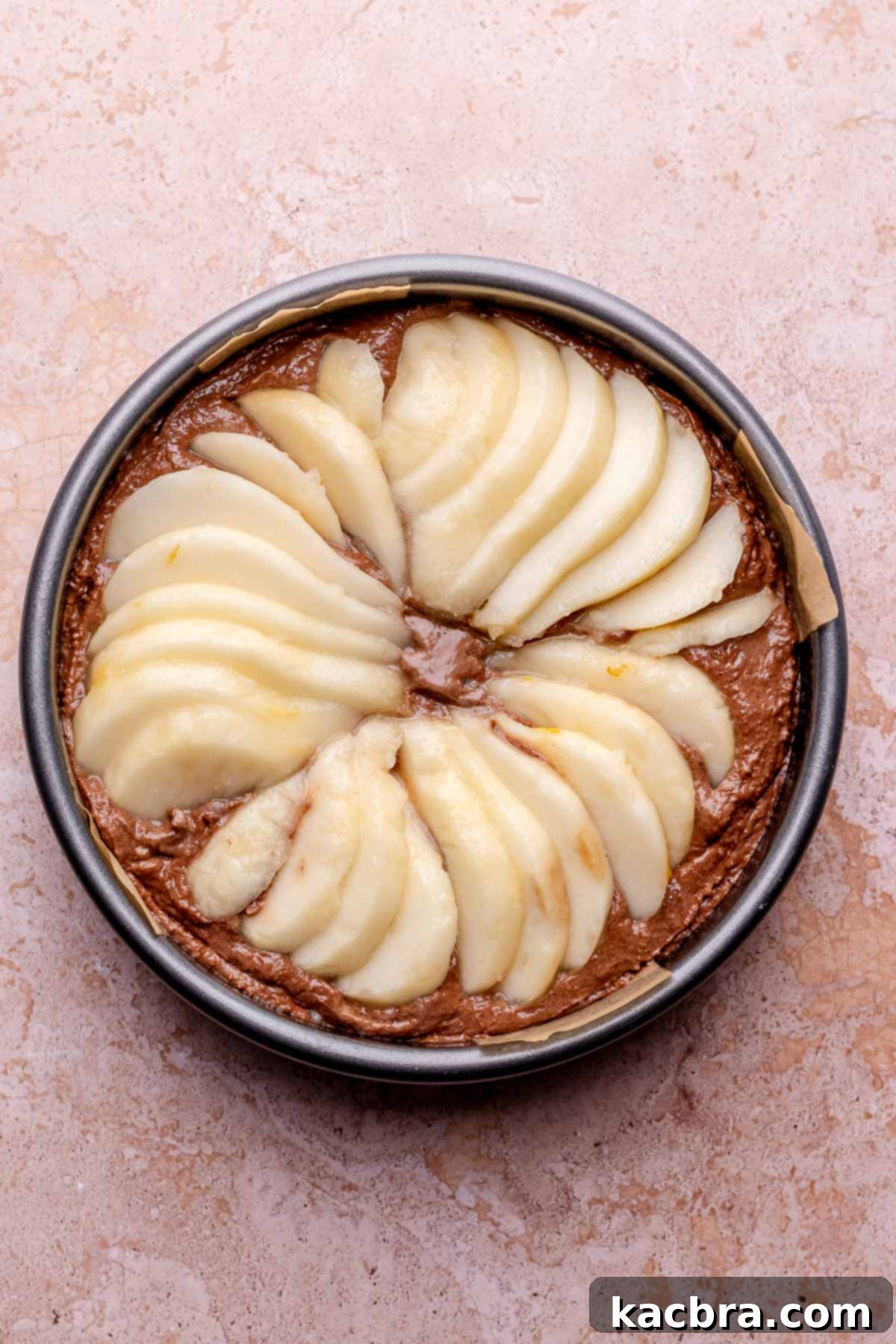 Pear-Kissed Chocolate Cake 9 Sliced pears fanned out on top of chocolate cake before baking.