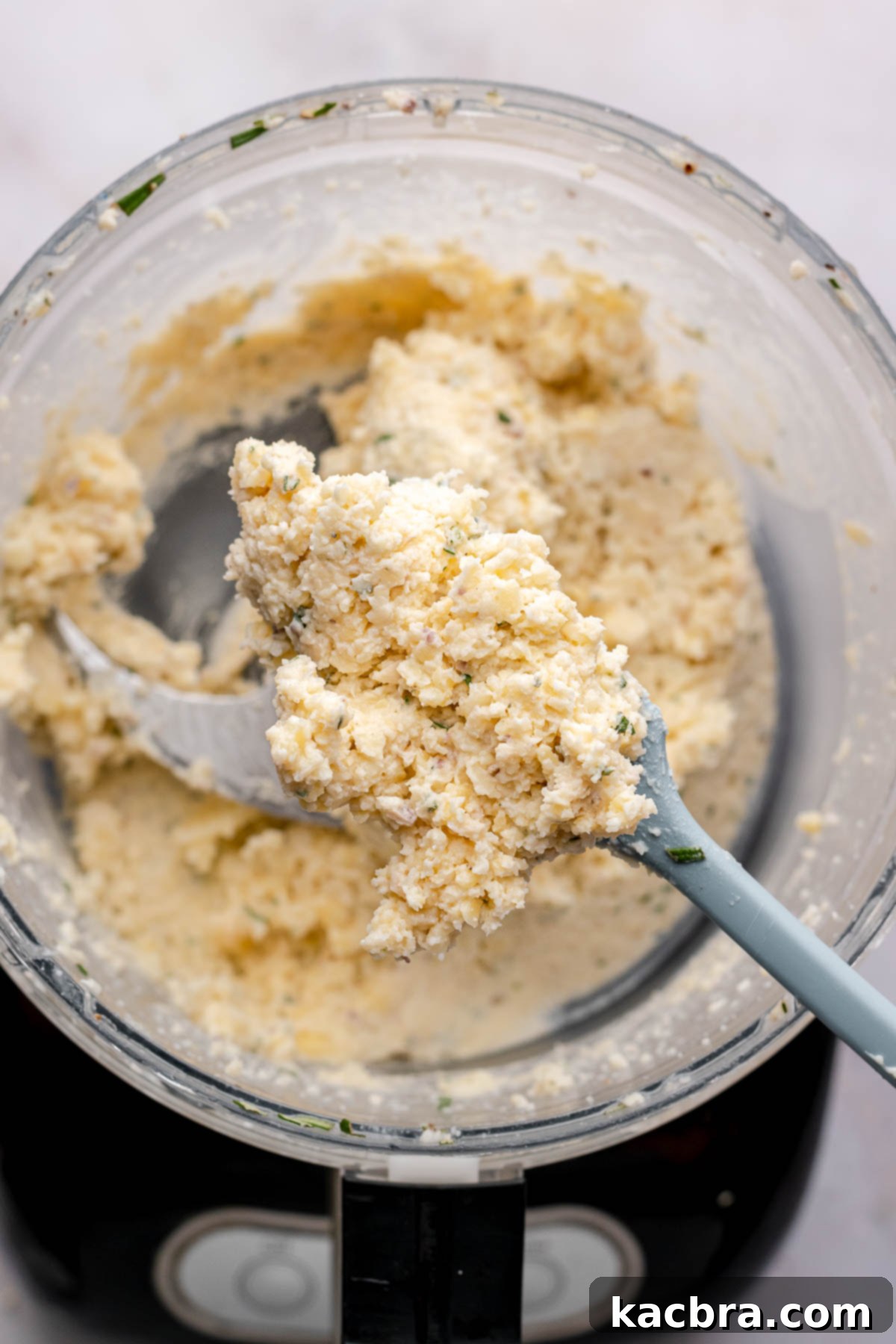 Intense Cheese Revival 6 A spatula holds fromage fort over a food processor.