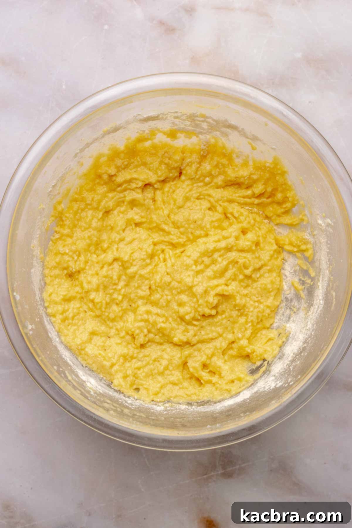 Almond cake batter in a bowl after adding dry ingredients.