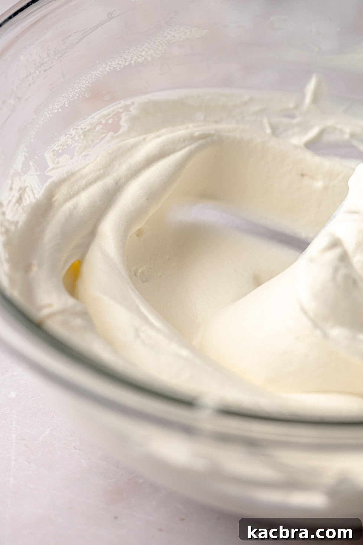 Fluffy coconut whipped cream in a mixing bowl.
