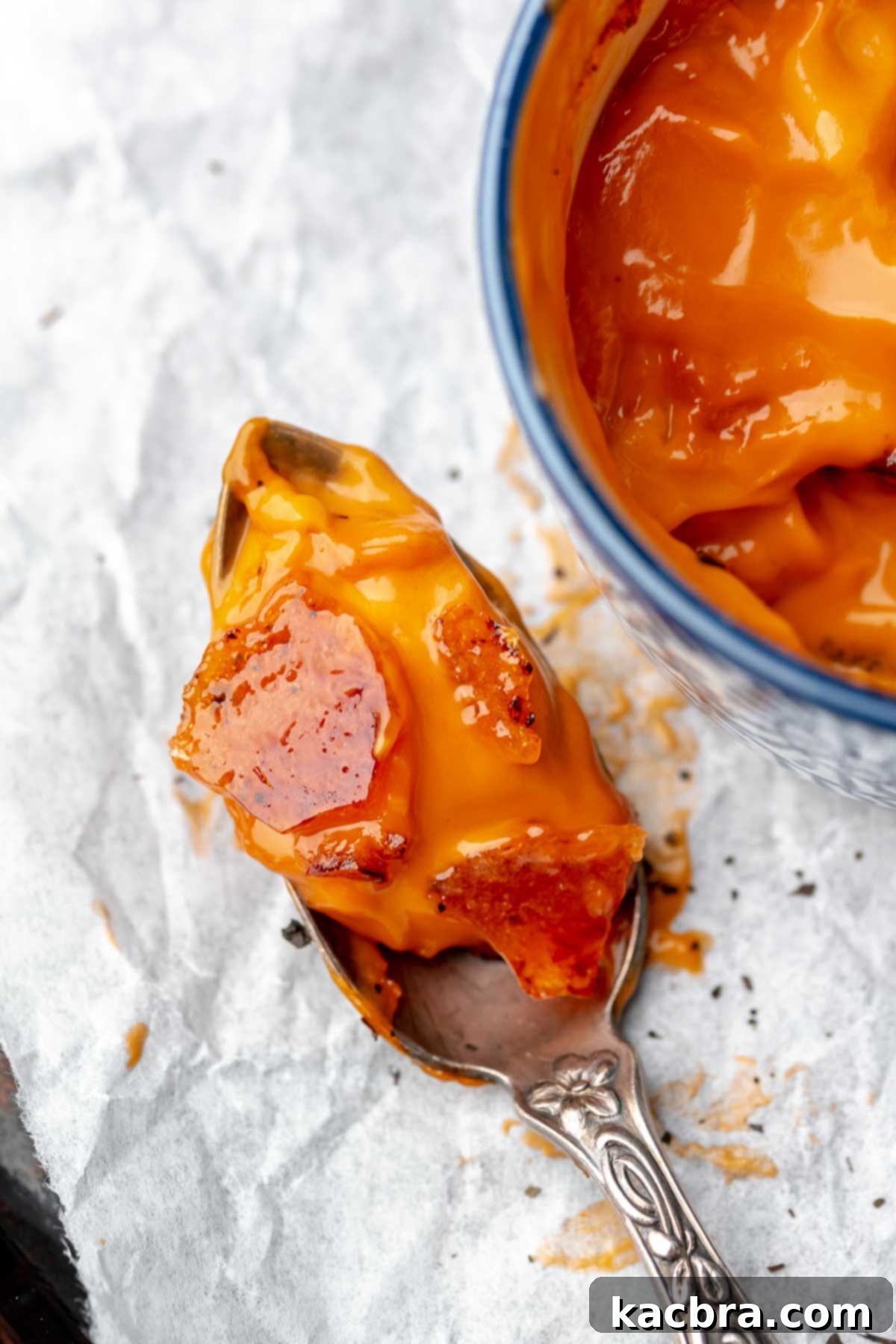 A spoon holds a scoop of thai tea creme brûlée.