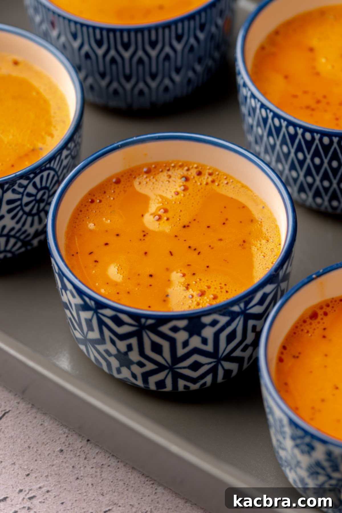 Thai tea custard in ramekins in a dish.