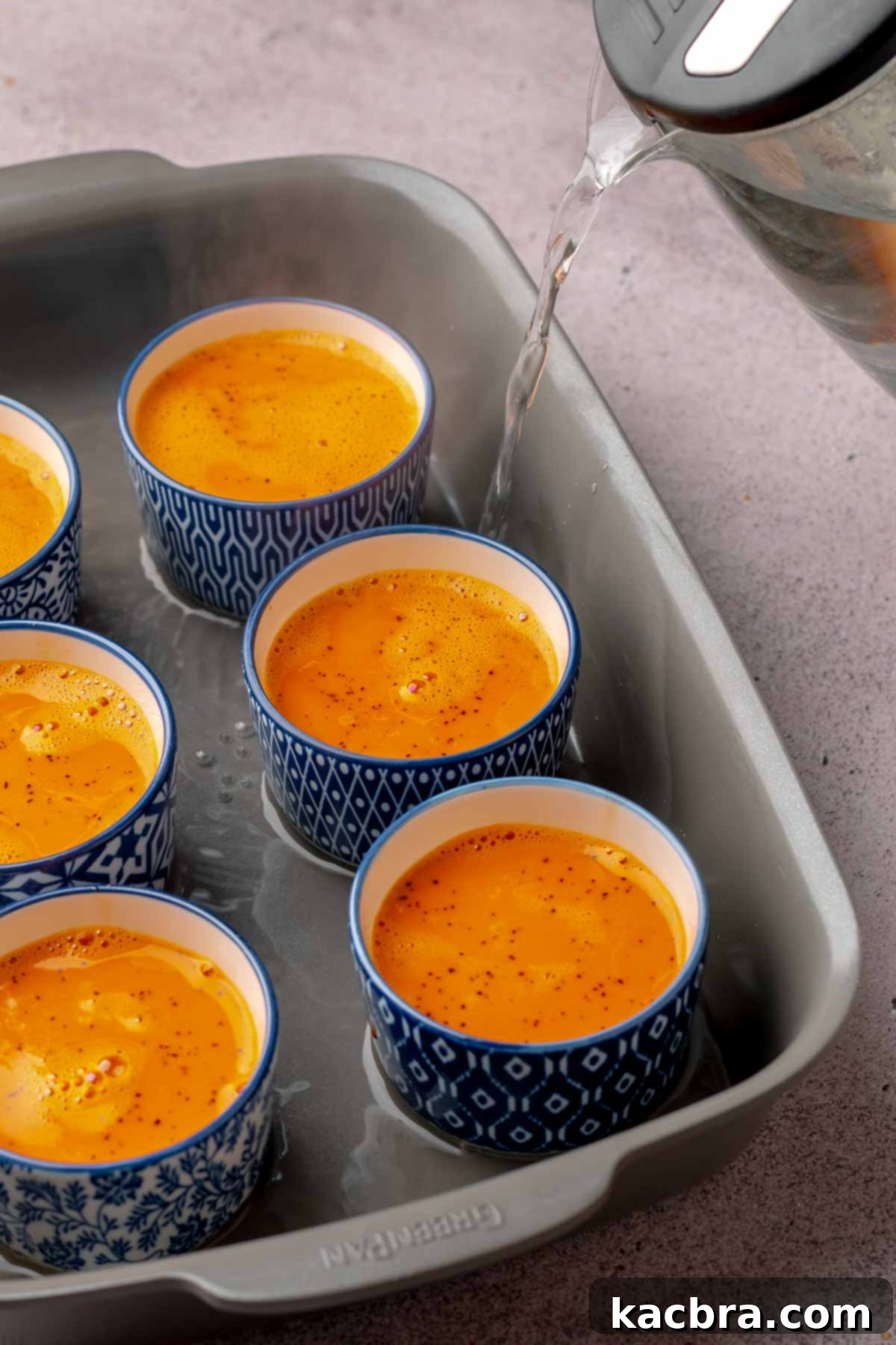 Hot water drizzles into a pan of ramekins.