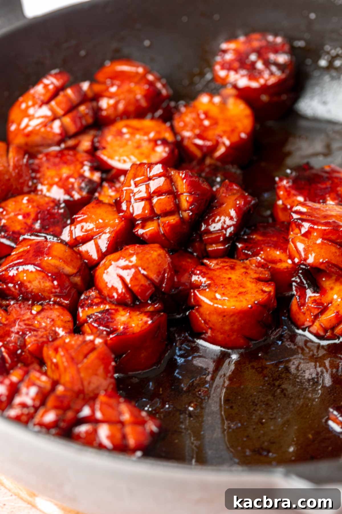 Glazed kielbasa in a frying pan.