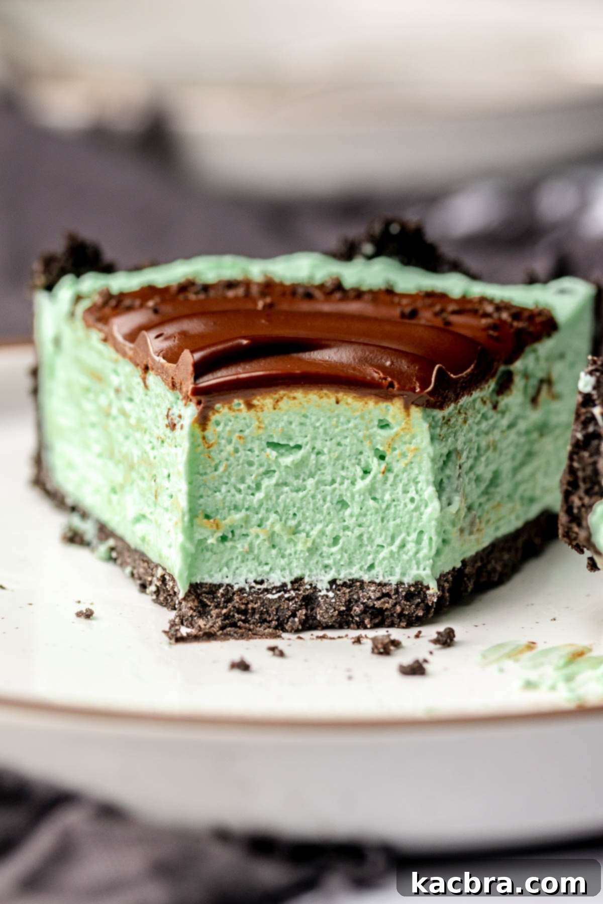 A slice of mint pie on a plate with a bite removed.