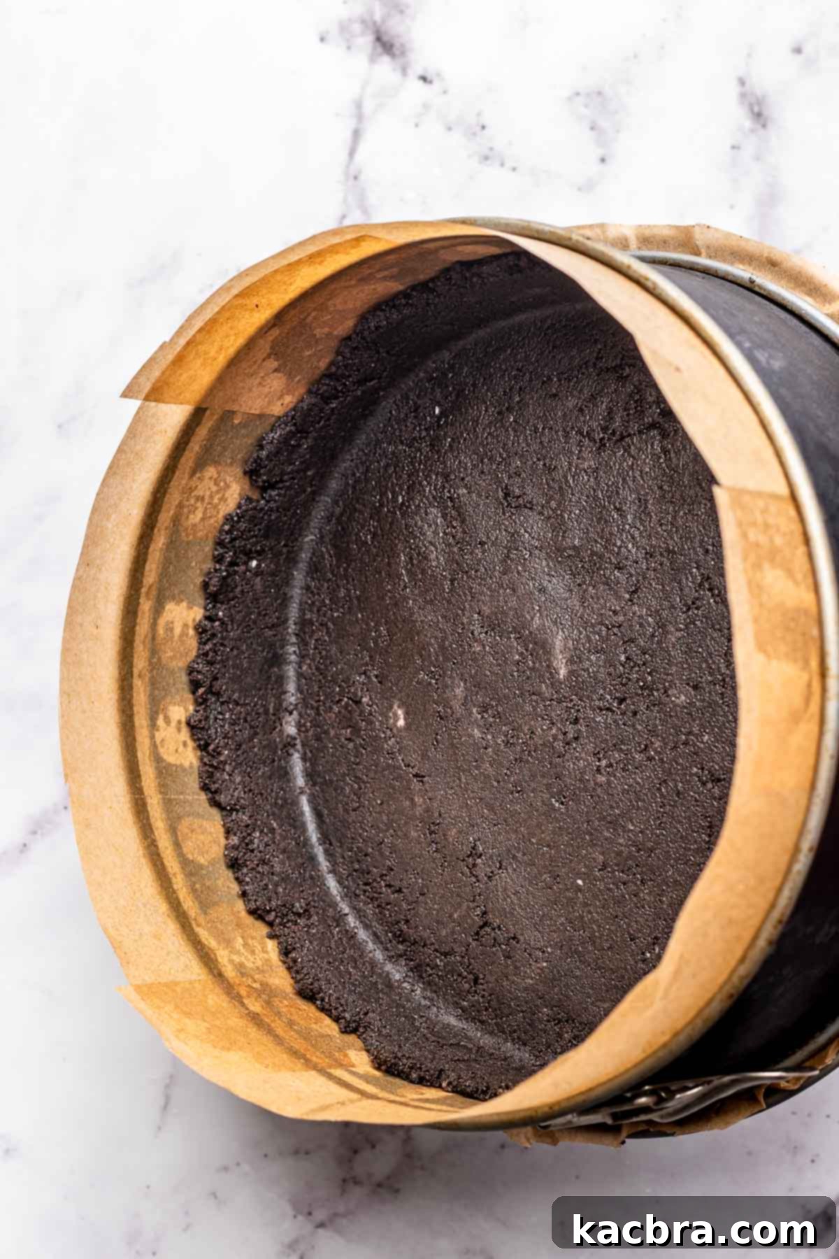 Oreo cookie crust pressed into a springform pan.