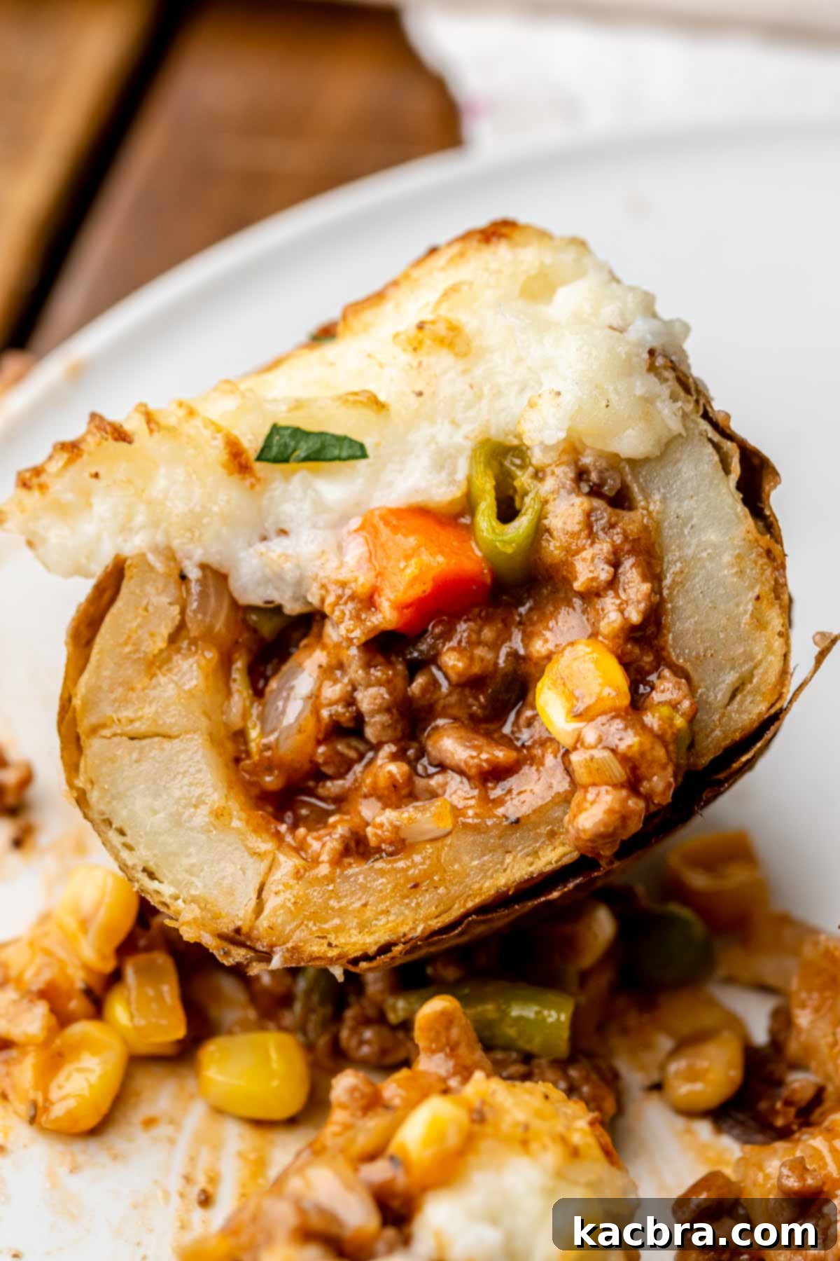 Cut open shepard's pie stuffed potato on a plate.