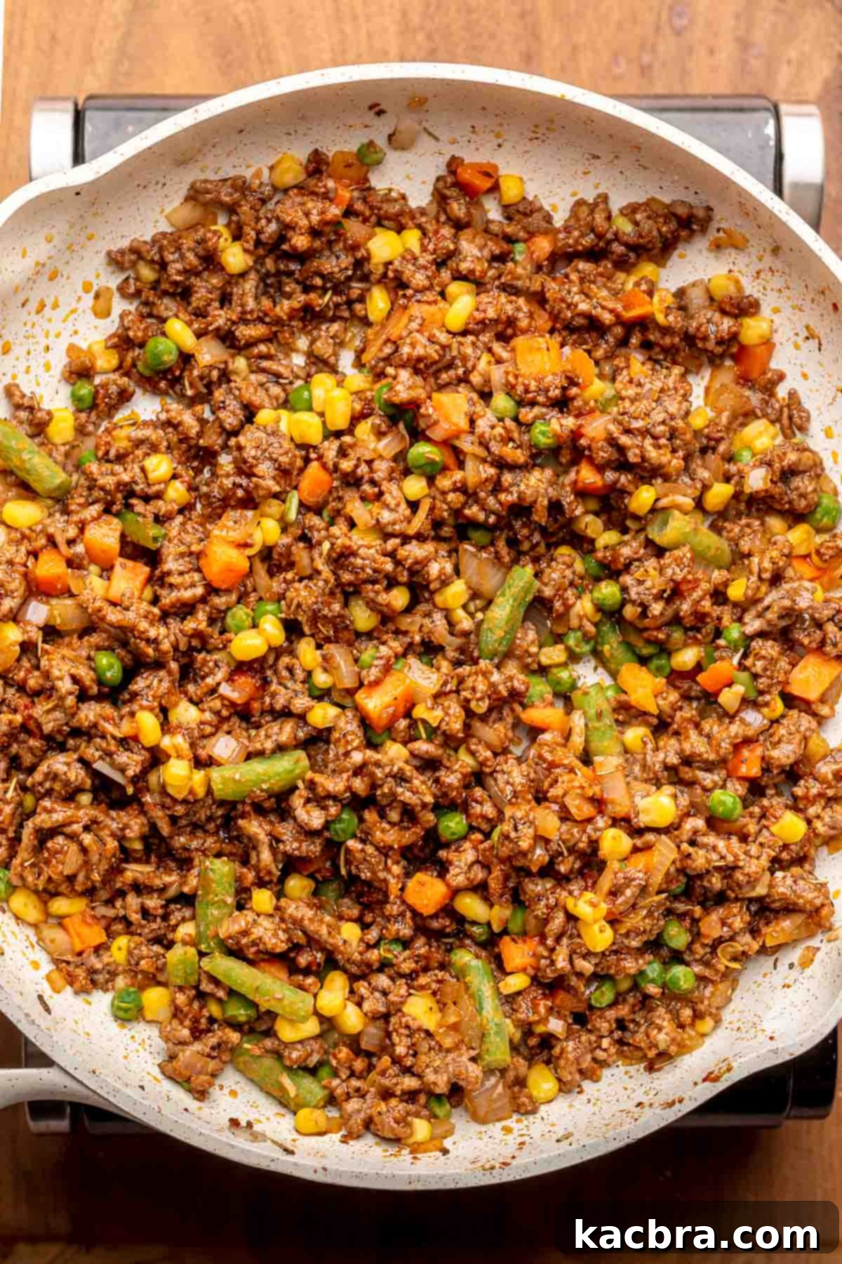 Browned meat and vegetables in a pan.