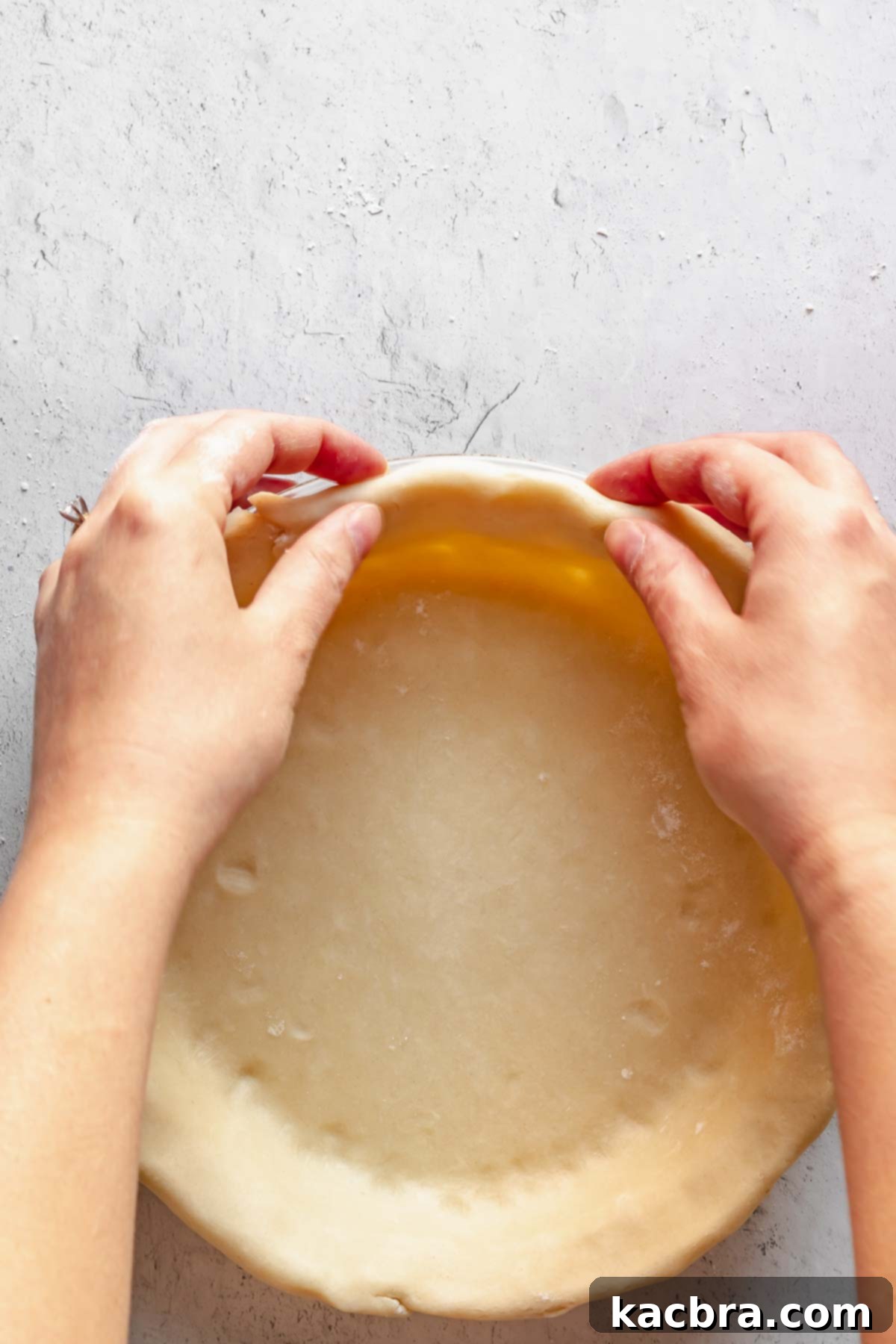 Perfectly Flaky All-Butter Crust 12 Hands folding pie dough edges under to create a reinforced rim.