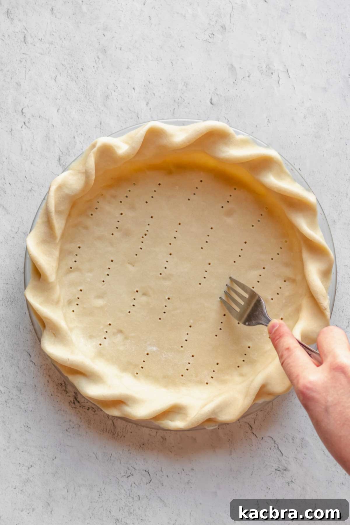 A pie crust with its bottom and sides docked with a fork, creating small holes to prevent puffing.