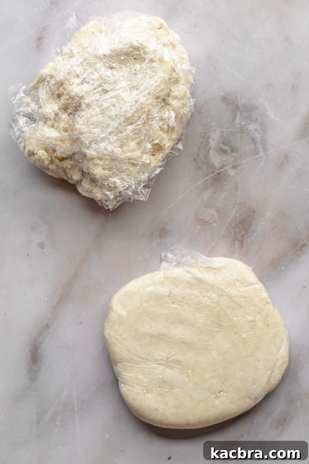 Perfectly Flaky All-Butter Crust 9 Two flattened discs of pie dough wrapped in plastic wrap, showing no cracks.