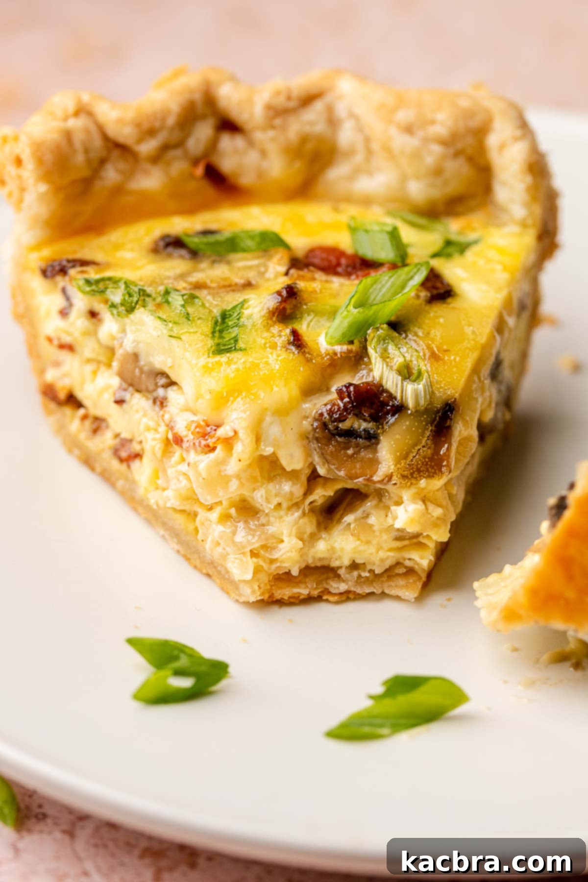 A perfectly baked slice of bacon mushroom quiche with a golden crust and creamy filling.