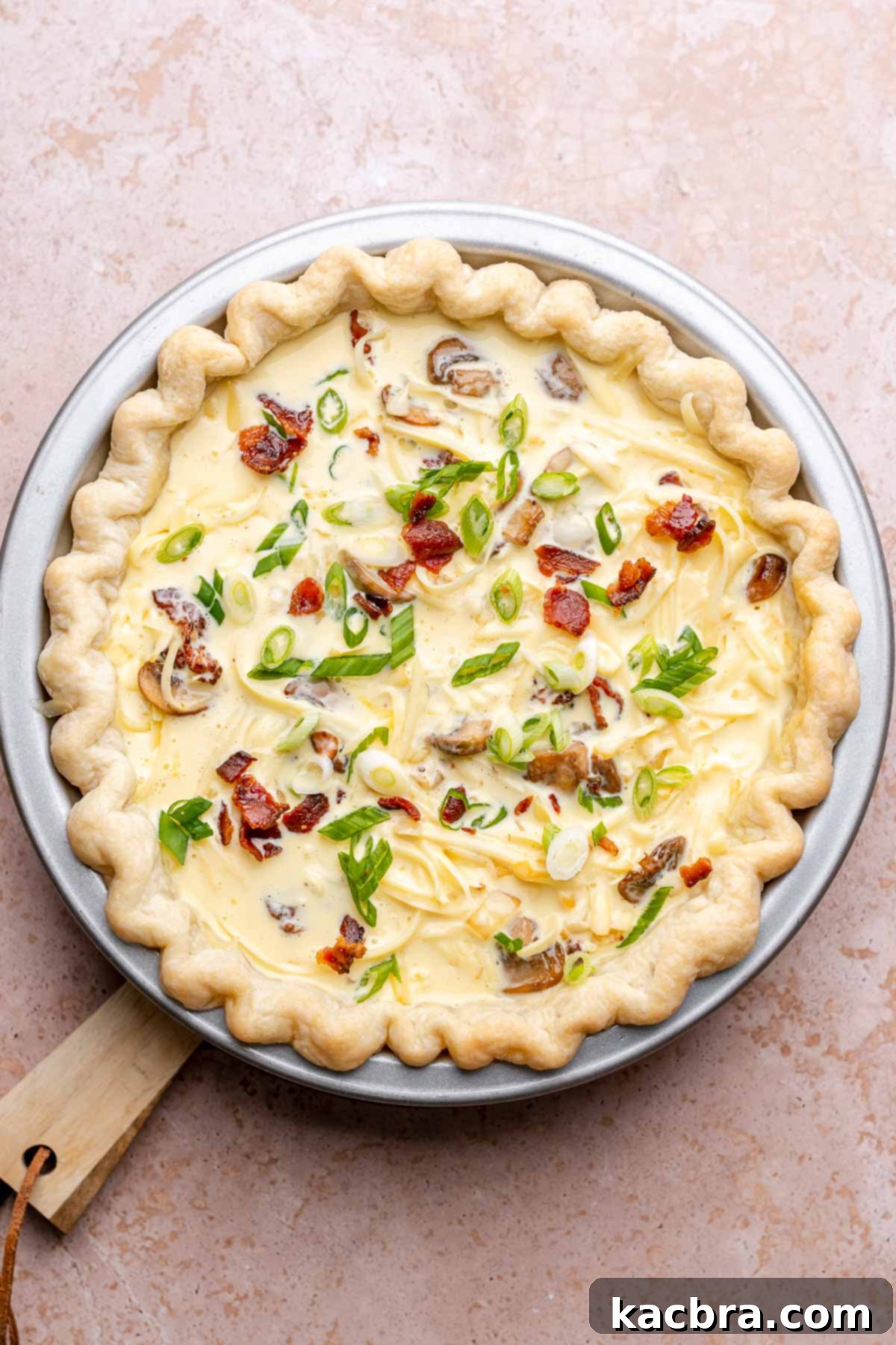 Assembled quiche, filled with custard, before baking.