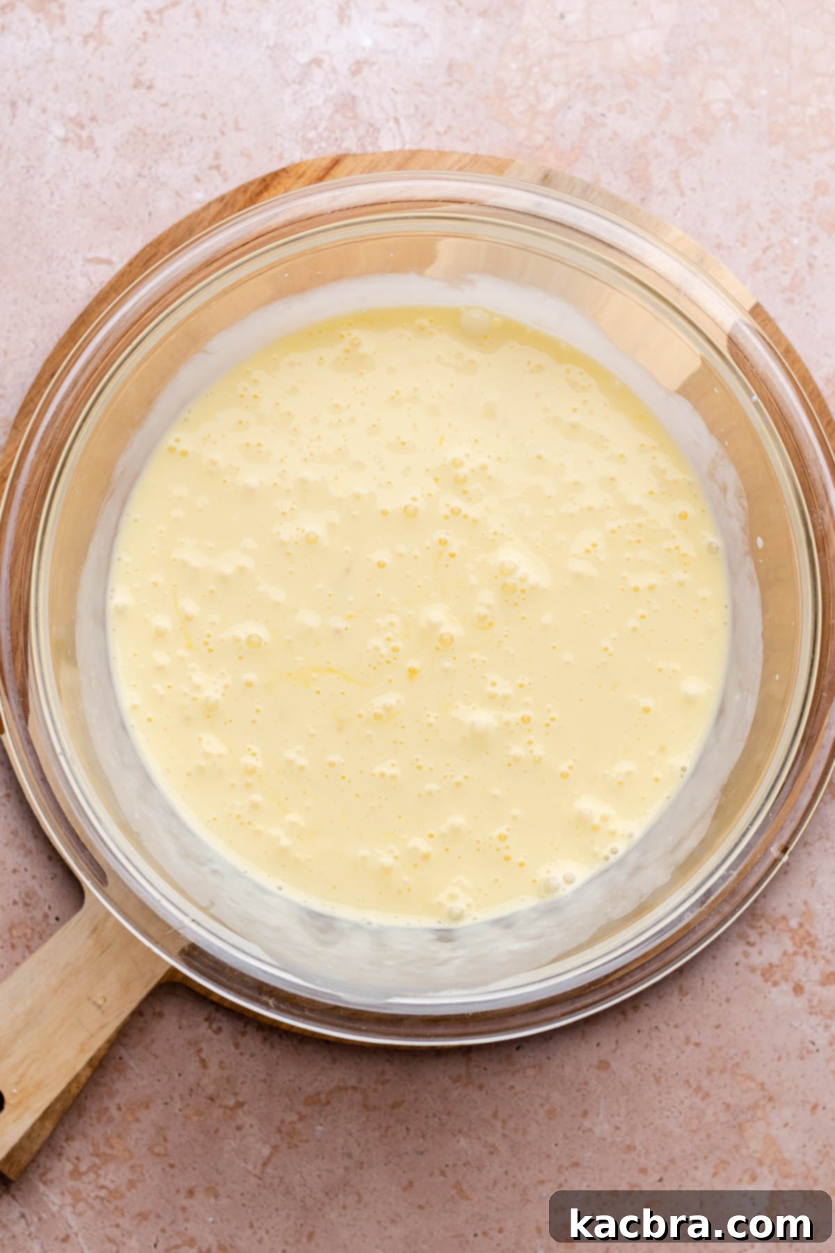 Egg custard mixture being whisked in a bowl until smooth.