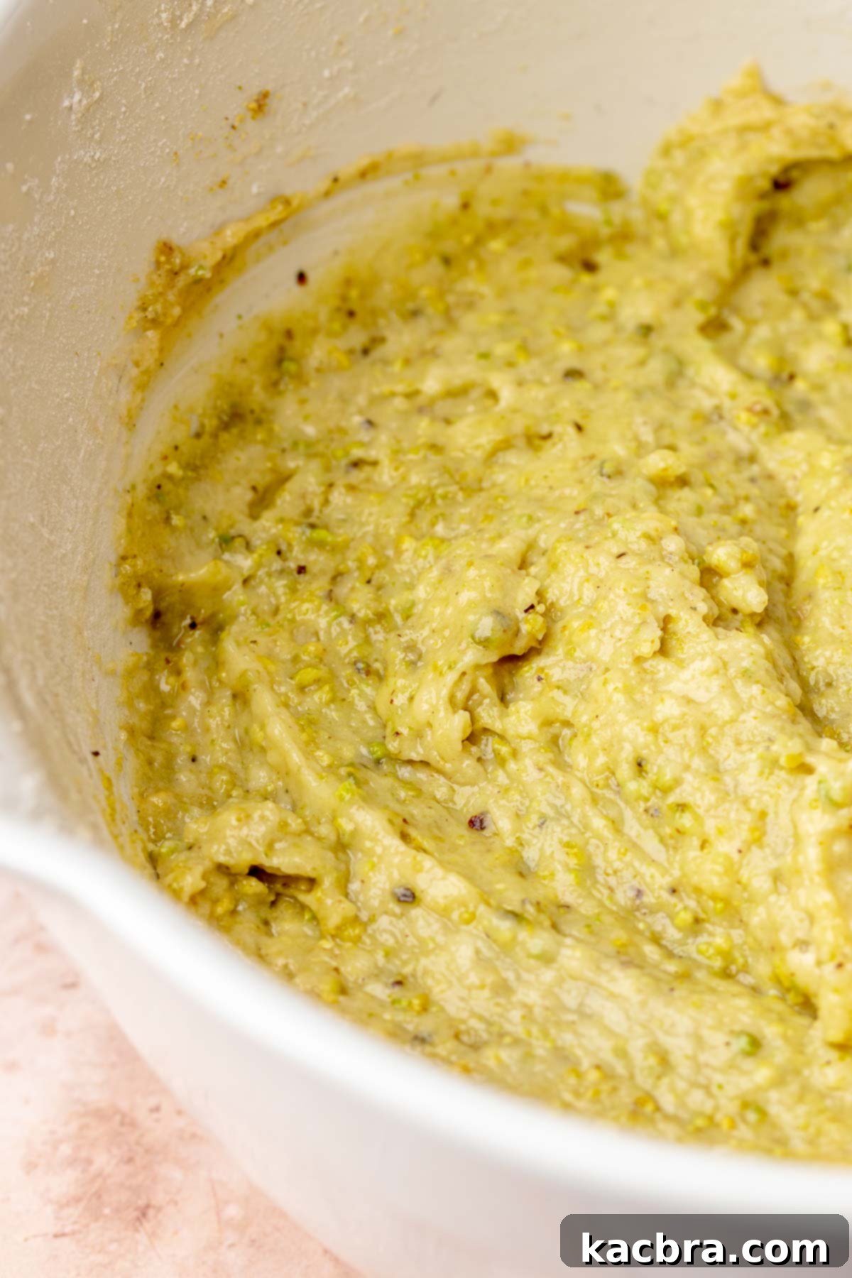 Golden Lemon Pistachio Dream with Honey Mascarpone Cloud 9 Dry ingredients and ground pistachios folded into the cake batter, showing a subtly green and textured mixture.