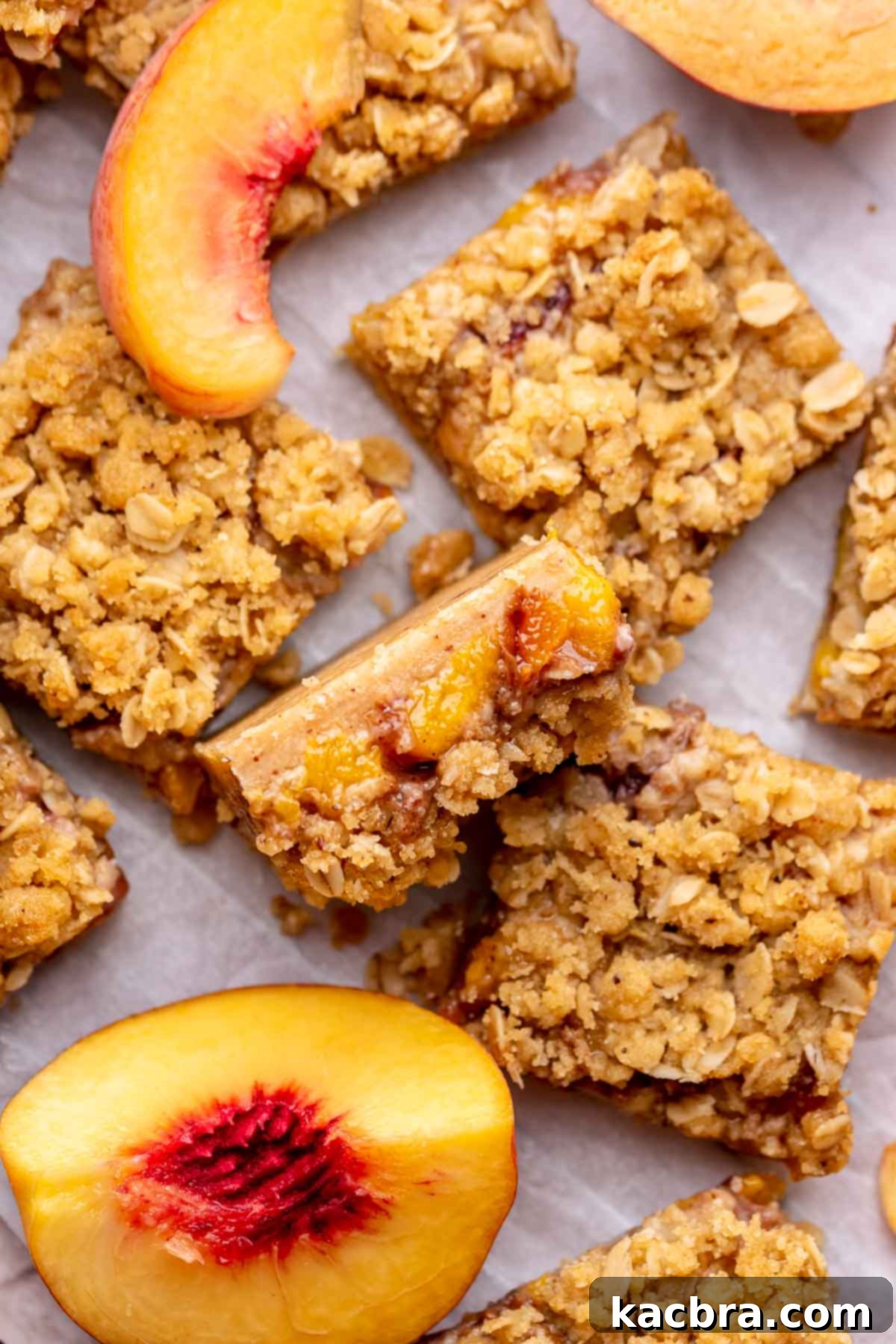 A perfectly sliced peach crumble bar, lying on its side, revealing all its delicious layers after chilling.