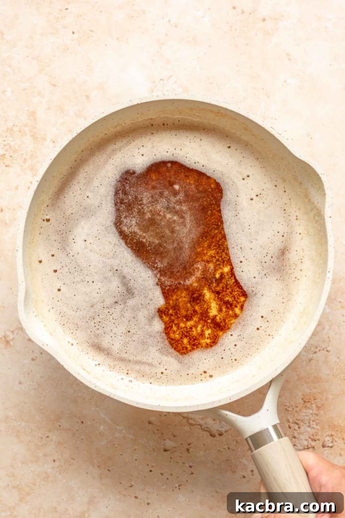 Brown butter shimmering in a frying pan, indicating it's ready to be cooled.