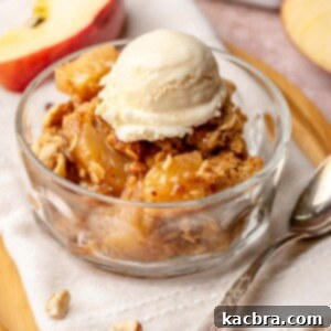 Toffee apple hazelnut crumble in a bowl with ice cream on top.