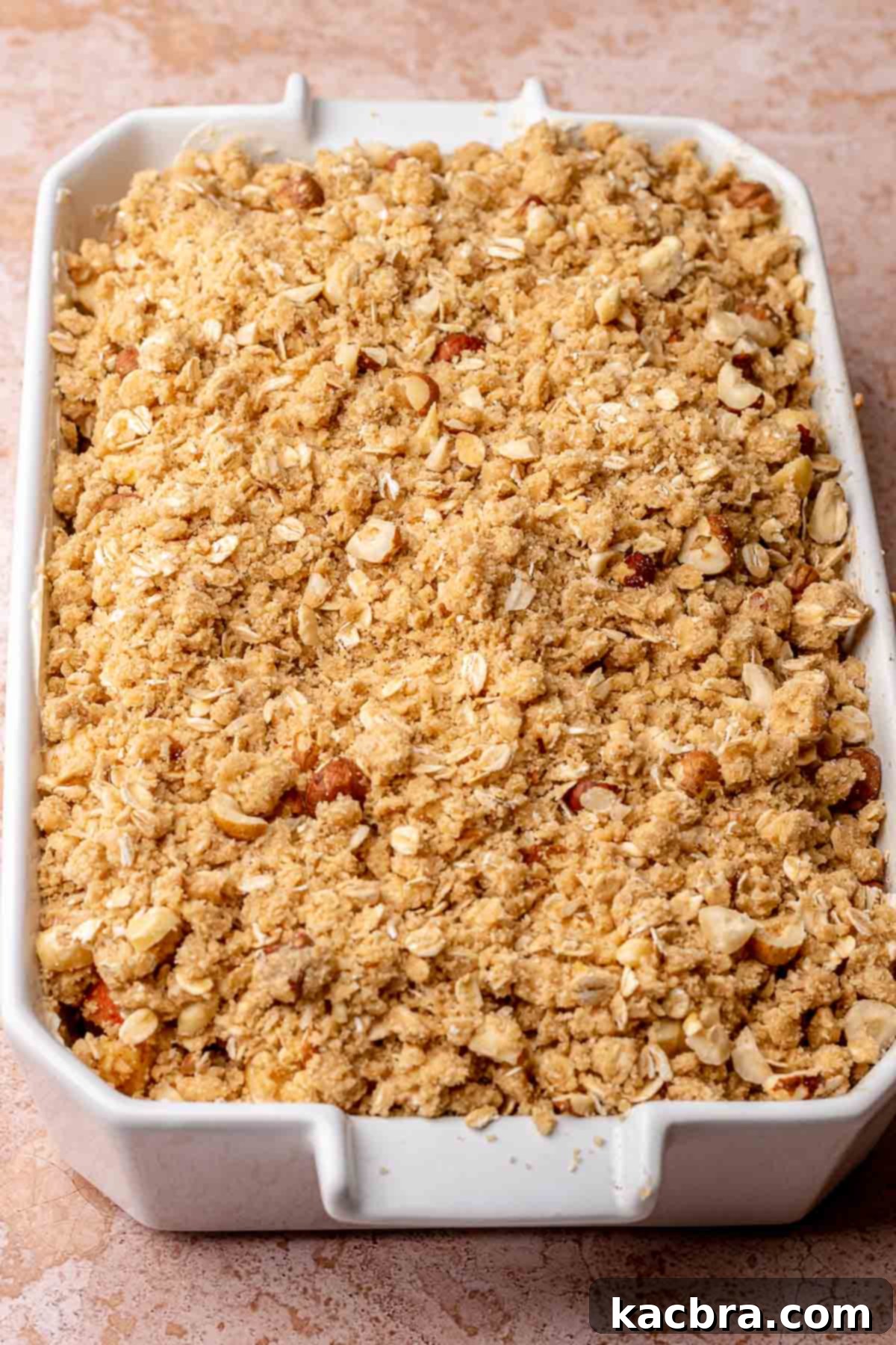 The Toffee Apple Crumble in a baking dish, topped with the hazelnut oat crumble, before being baked.