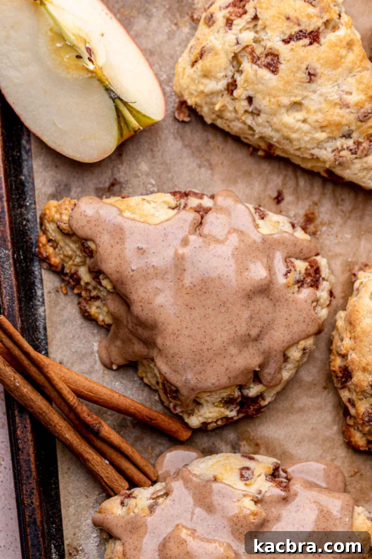 Cinnamon-Kissed Apple Scones 13 An iced cinnamon apple scone on a sheet pan.