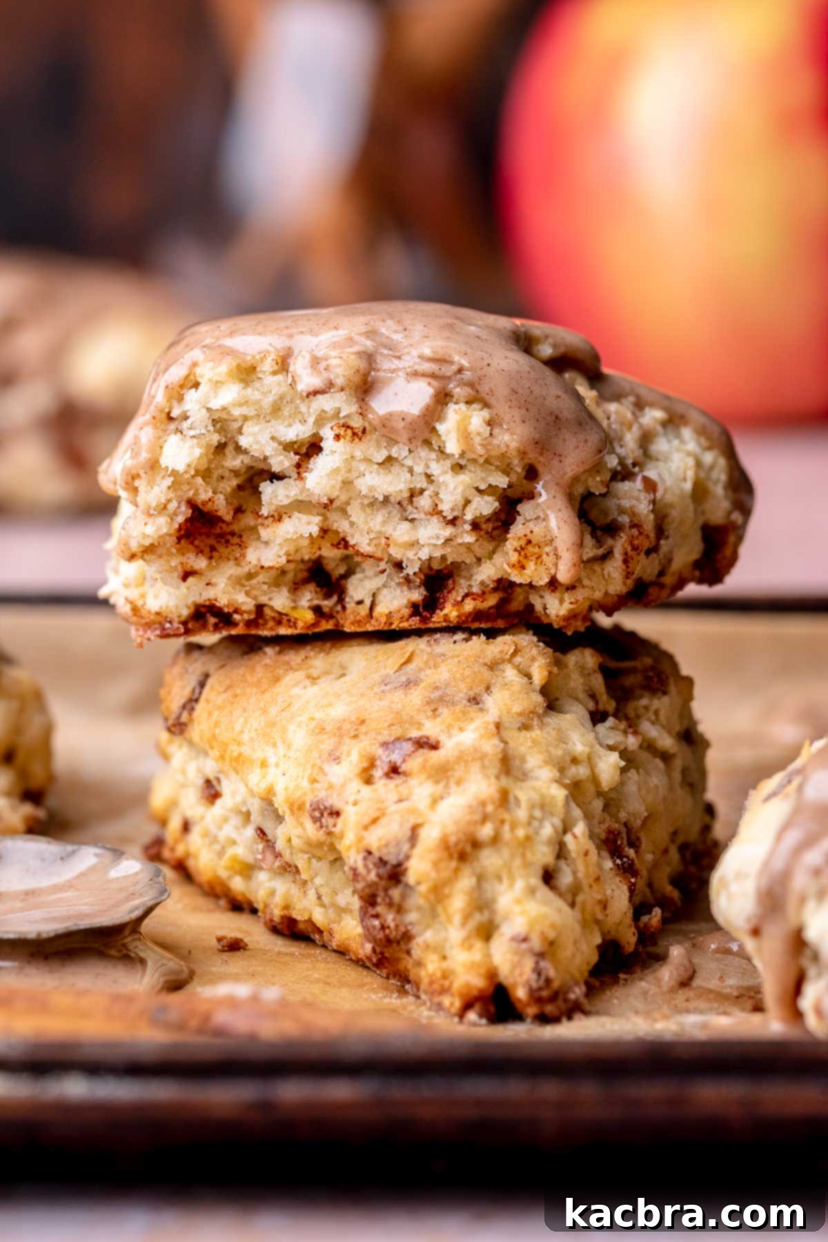 Cinnamon-Kissed Apple Scones 14 A stack of apple cinnamon scones. The top scone is broken open.