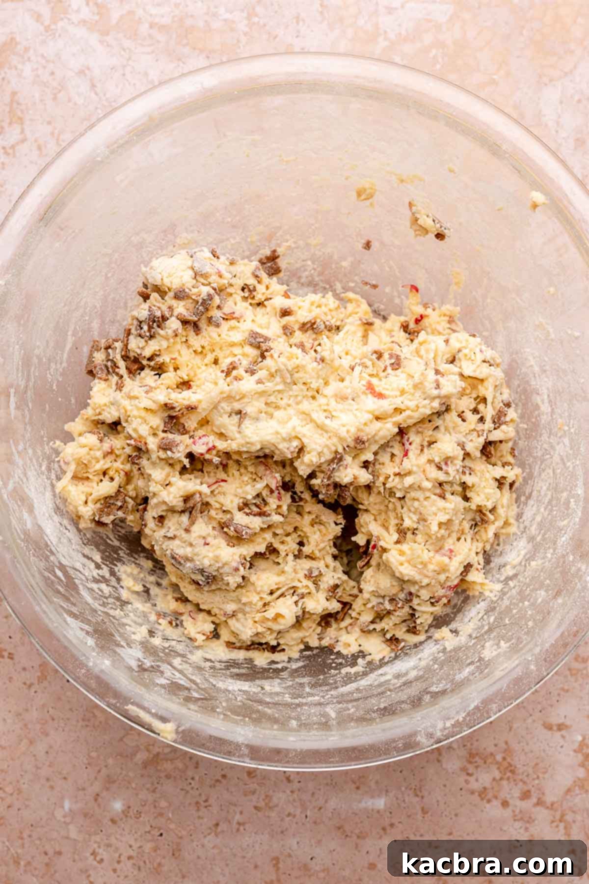 Mixed apple cinnamon scone dough in a bowl, showing the combined wet and dry ingredients.