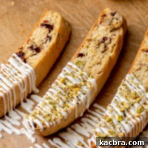 Three pieces of biscotti with white chocolate drizzled on top.