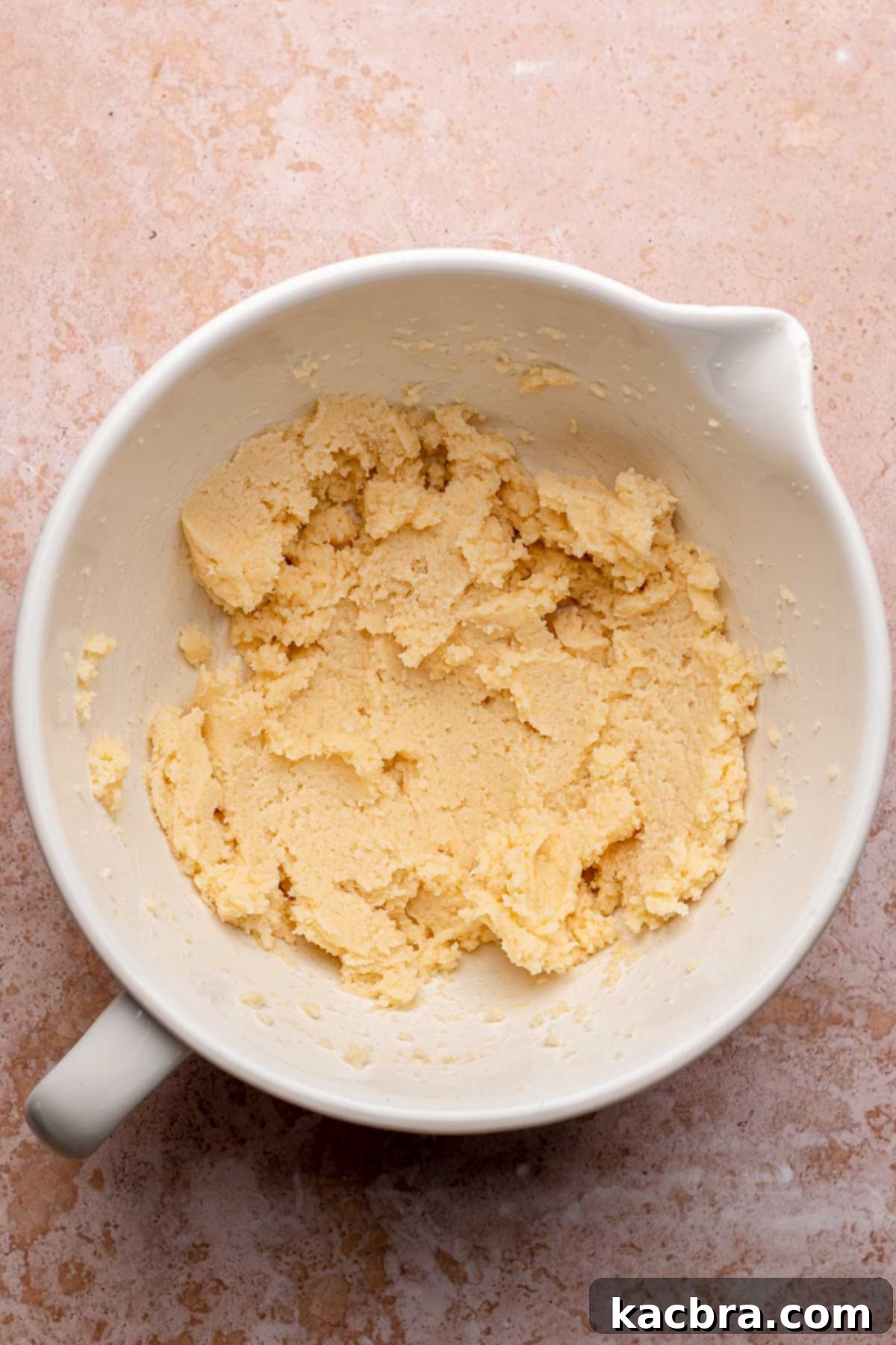 Butter and granulated sugar creamed together to a light and fluffy consistency in a mixing bowl.