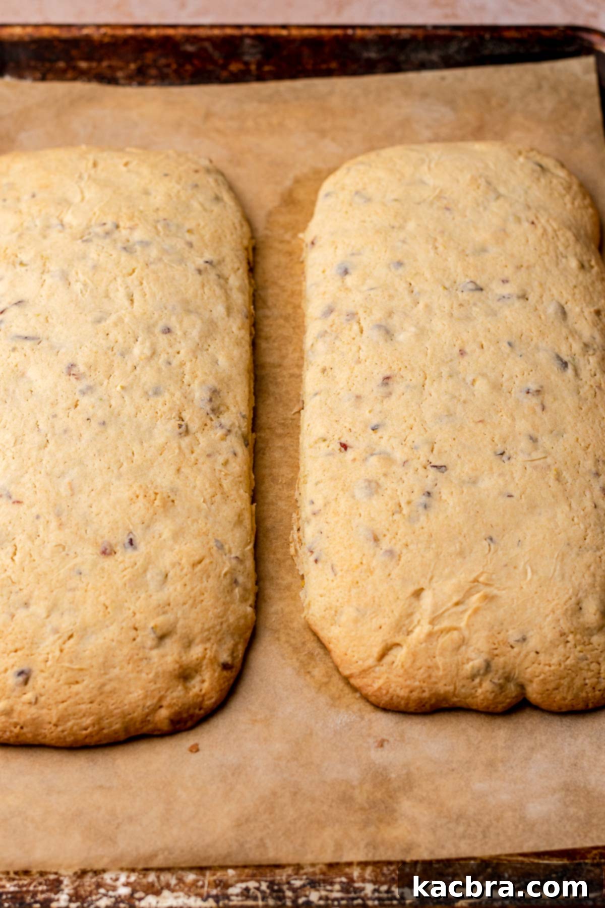 Two planks of baked biscotti mounds on a sheet pan.