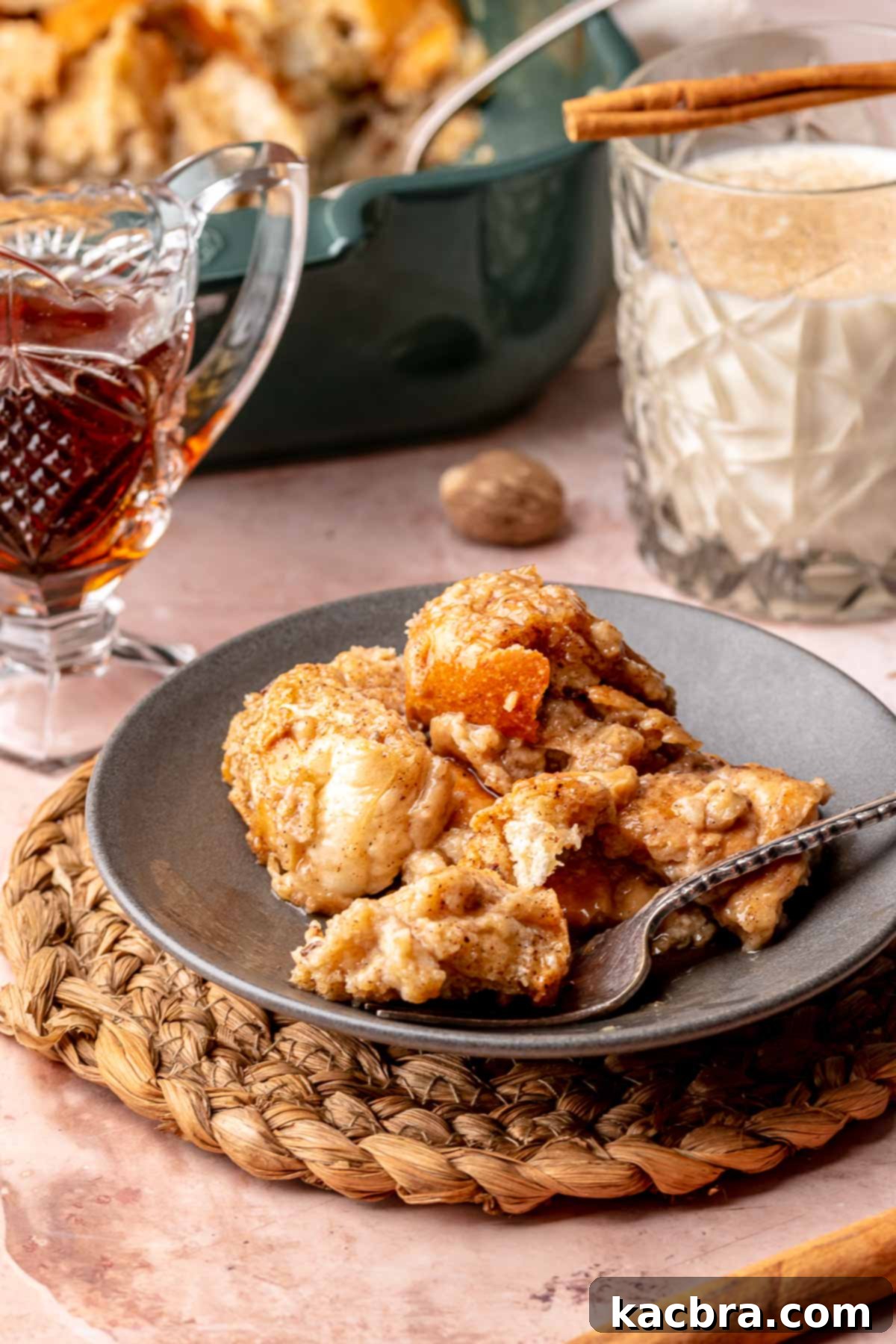 French toast casserole plated in a bowl with a fork, drizzled with syrup.