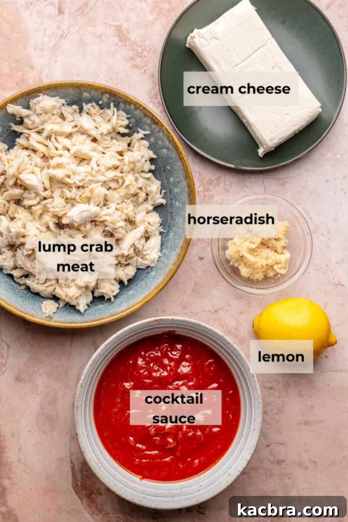 Ingredients laid out for cold crab dip: cream cheese, lump crab meat, cocktail sauce, lemon, and horseradish.