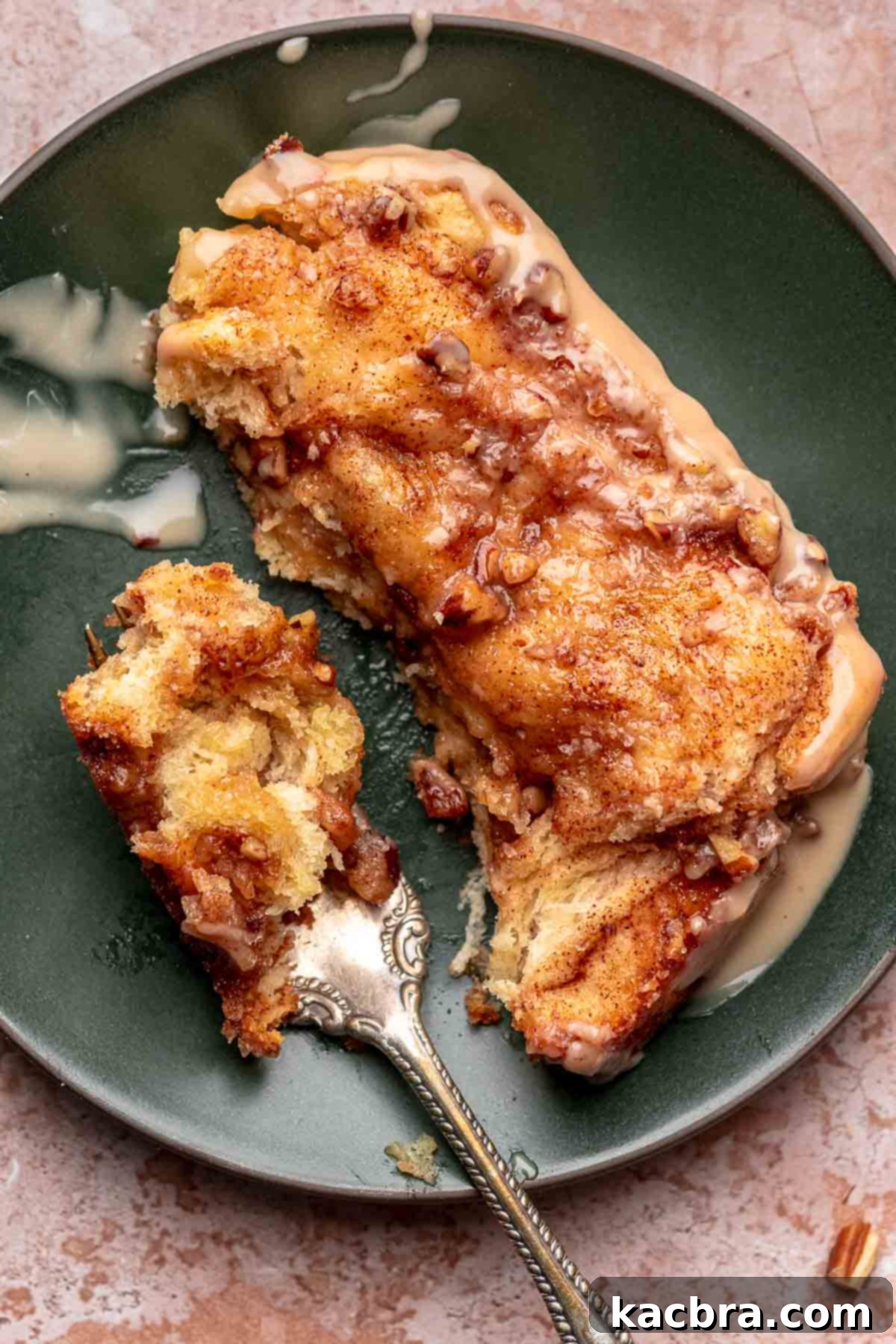 A single piece of maple pecan cinnamon pull apart bread on a white plate with a fork.