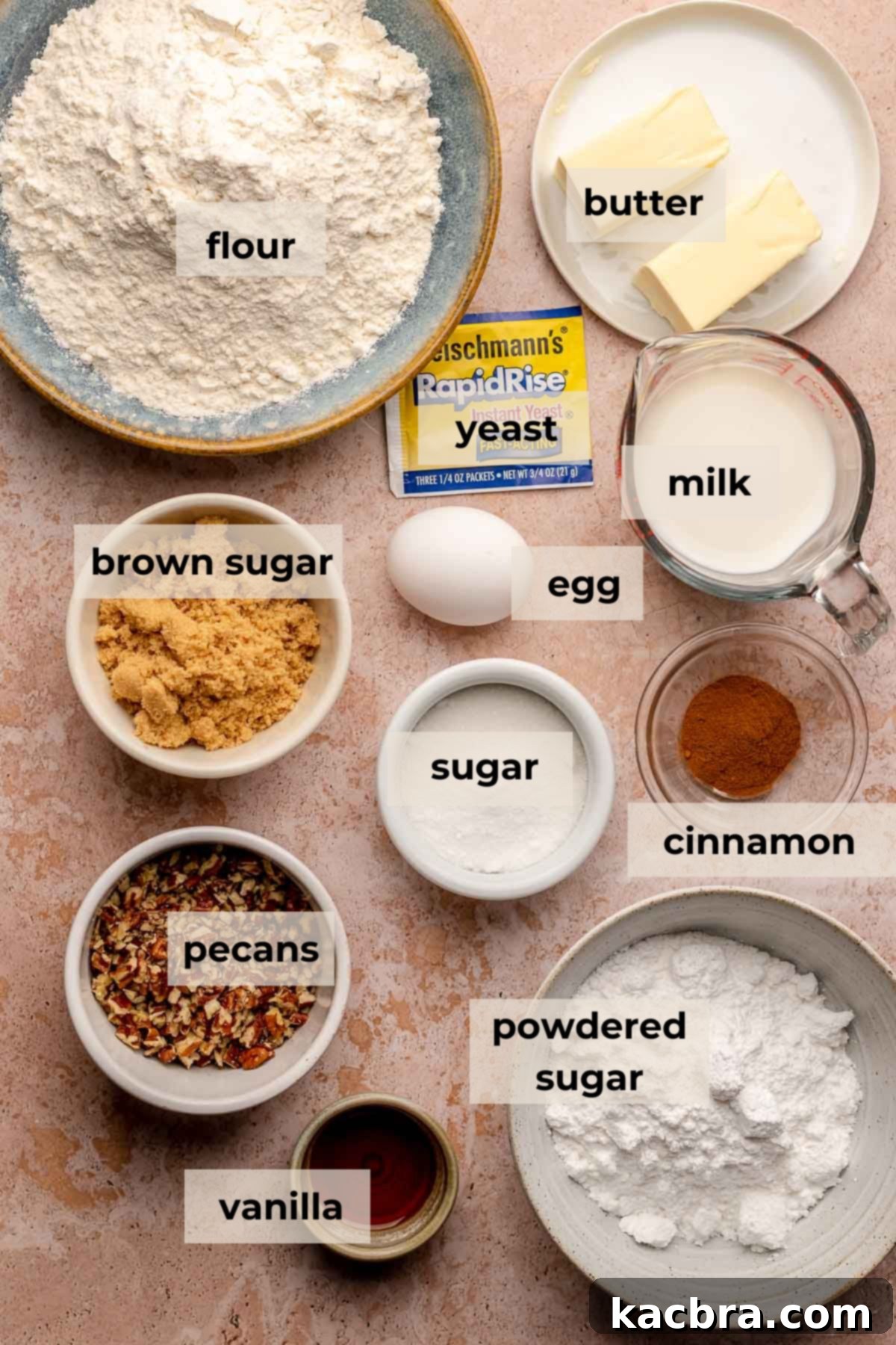 Assortment of ingredients for maple pecan cinnamon pull apart bread including flour, butter, eggs, yeast, sugar, cinnamon, pecans, and maple syrup.