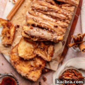 Cinnamon pull apart bread on a cutting board with two slices pulled down.