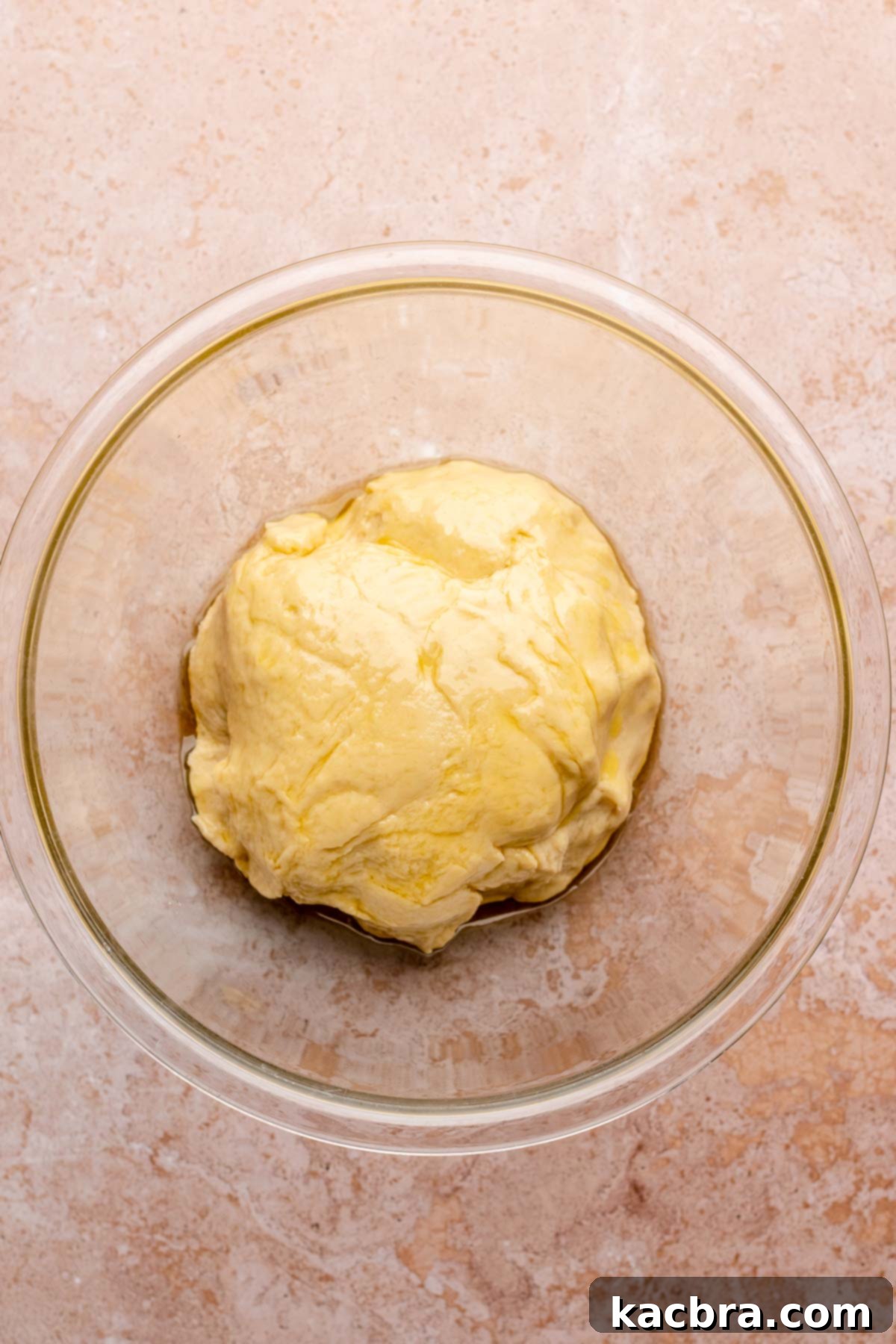 Oiled dough in a mixing bowl ready to begin its first rise.