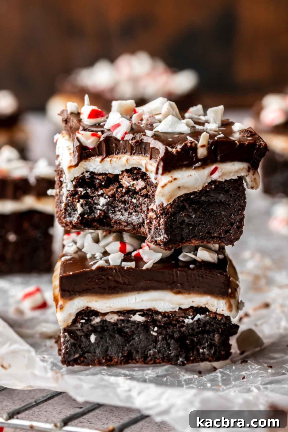 Two peppermint brownies stacked on top of each other. The top has a bite removed.