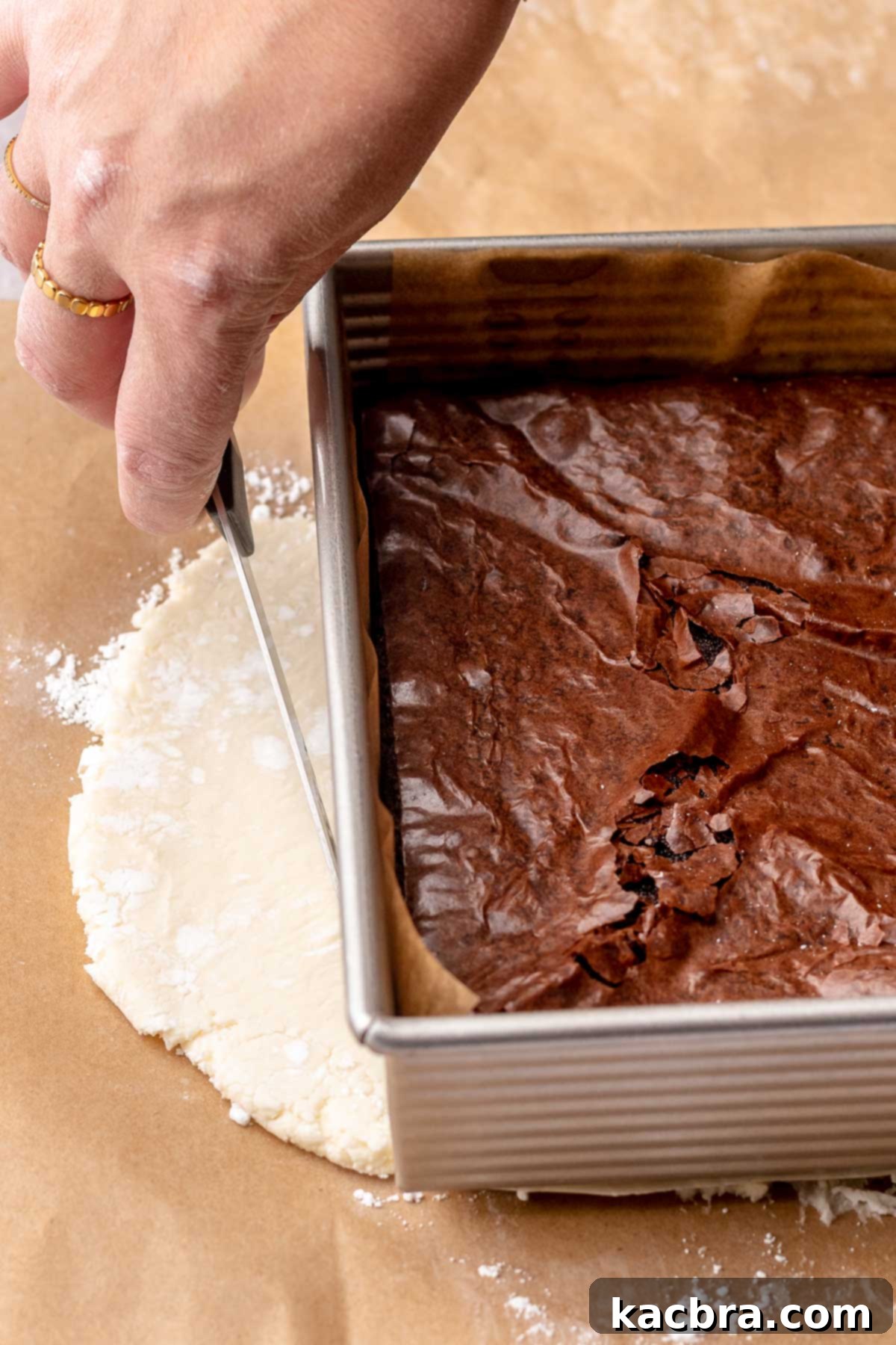 A hand cuts peppermint filling into a square.