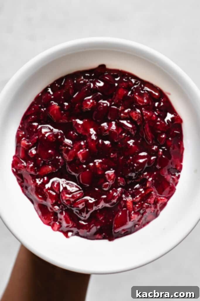 The cherry compote is cooking in a saucepan on the stove, sugar and cherries simmering to create a rich filling.