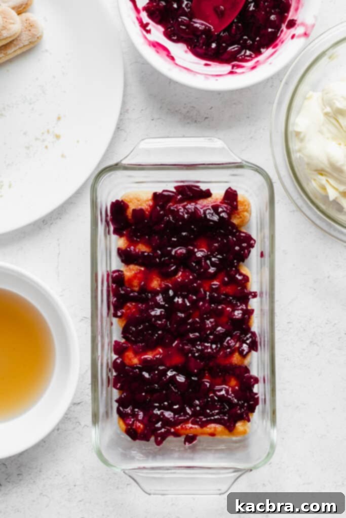 The first layer of Amaretto-dipped ladyfingers neatly lines the bottom of the loaf pan.