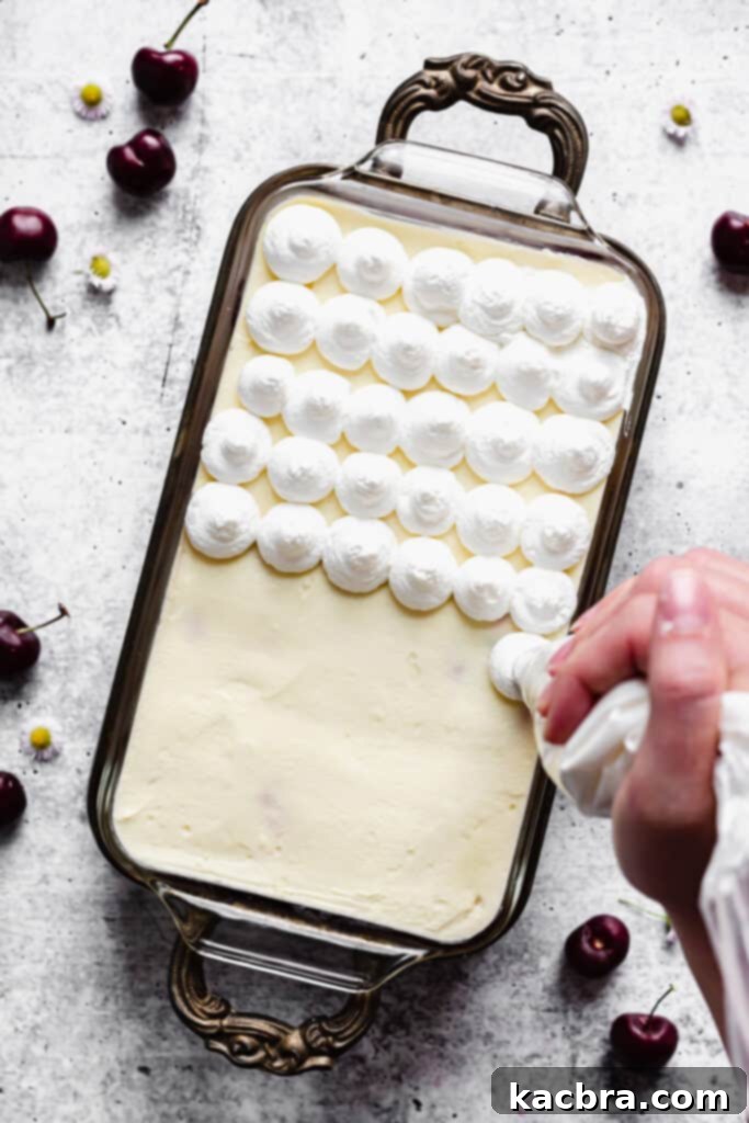 The tiramisu is ready for topping, showing the smooth mascarpone cream on the final layer.