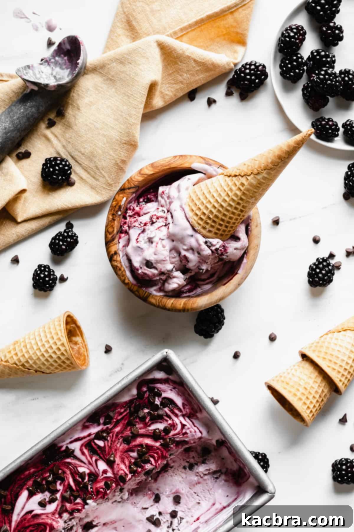 Overhead shot of a bowl of blackberry chip ice cream with a cone sitting inside.