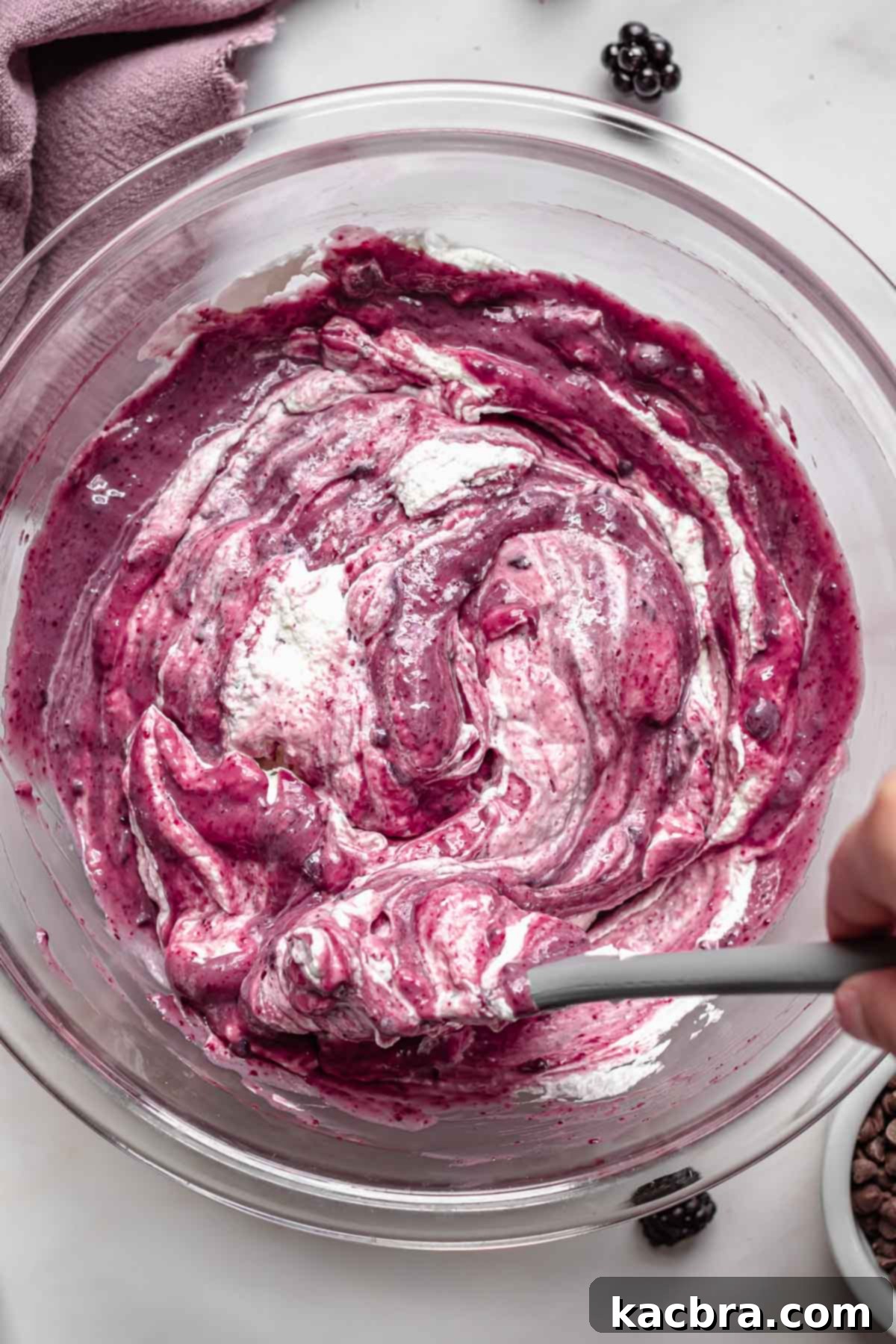 Whipped cream folding into black raspberry ice cream.
