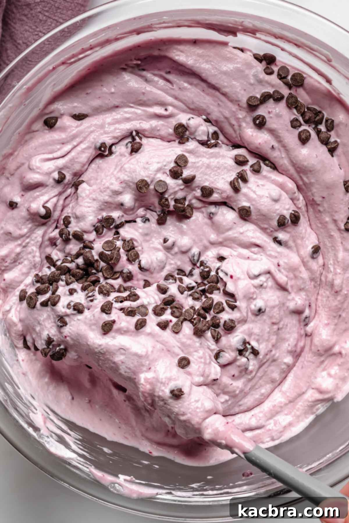 Folding mini chocolate chips into the ice cream base.